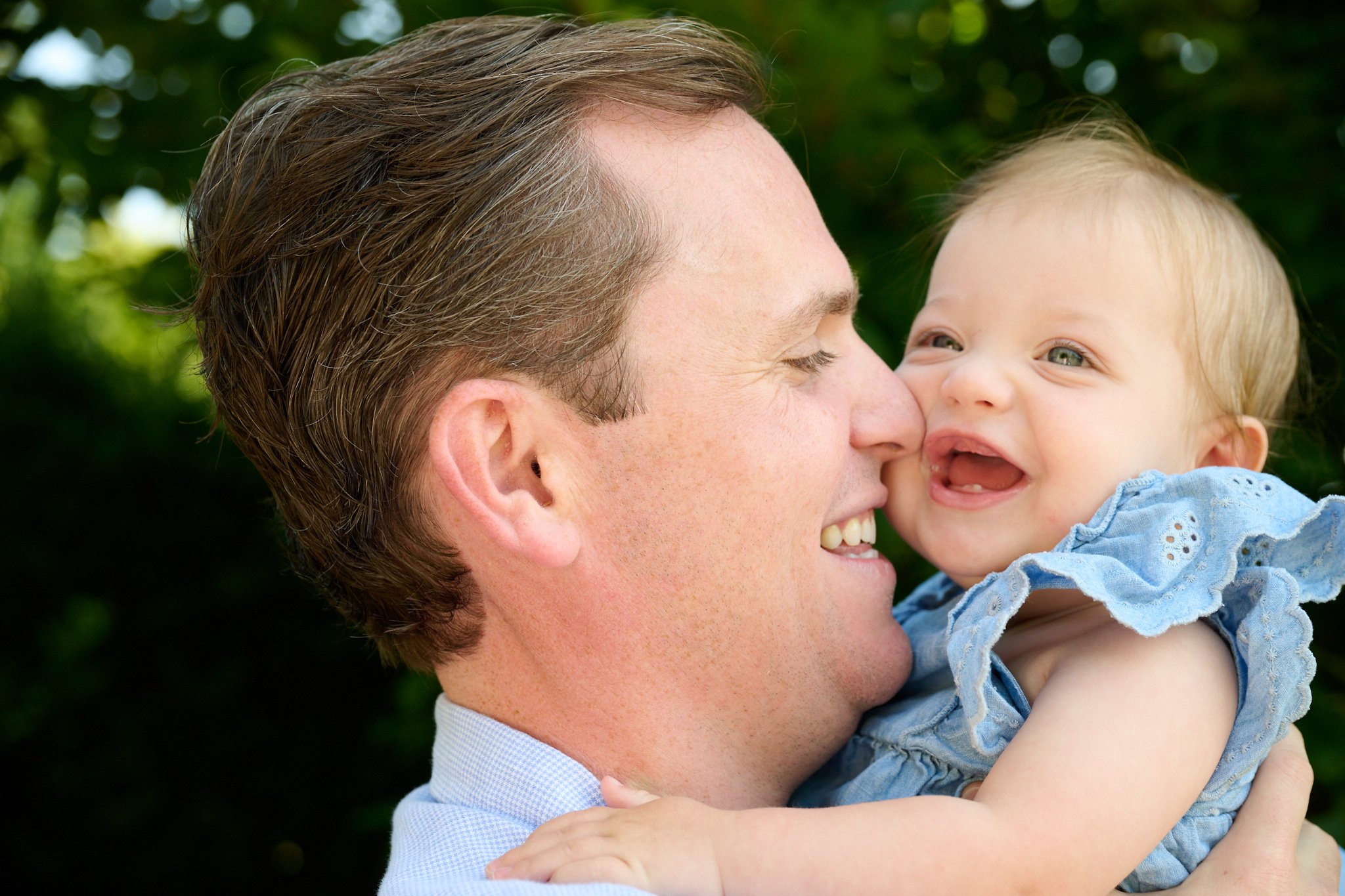 Dad and baby girl laugh in New Canaan CT park with family photographer Pamela Einarsen.