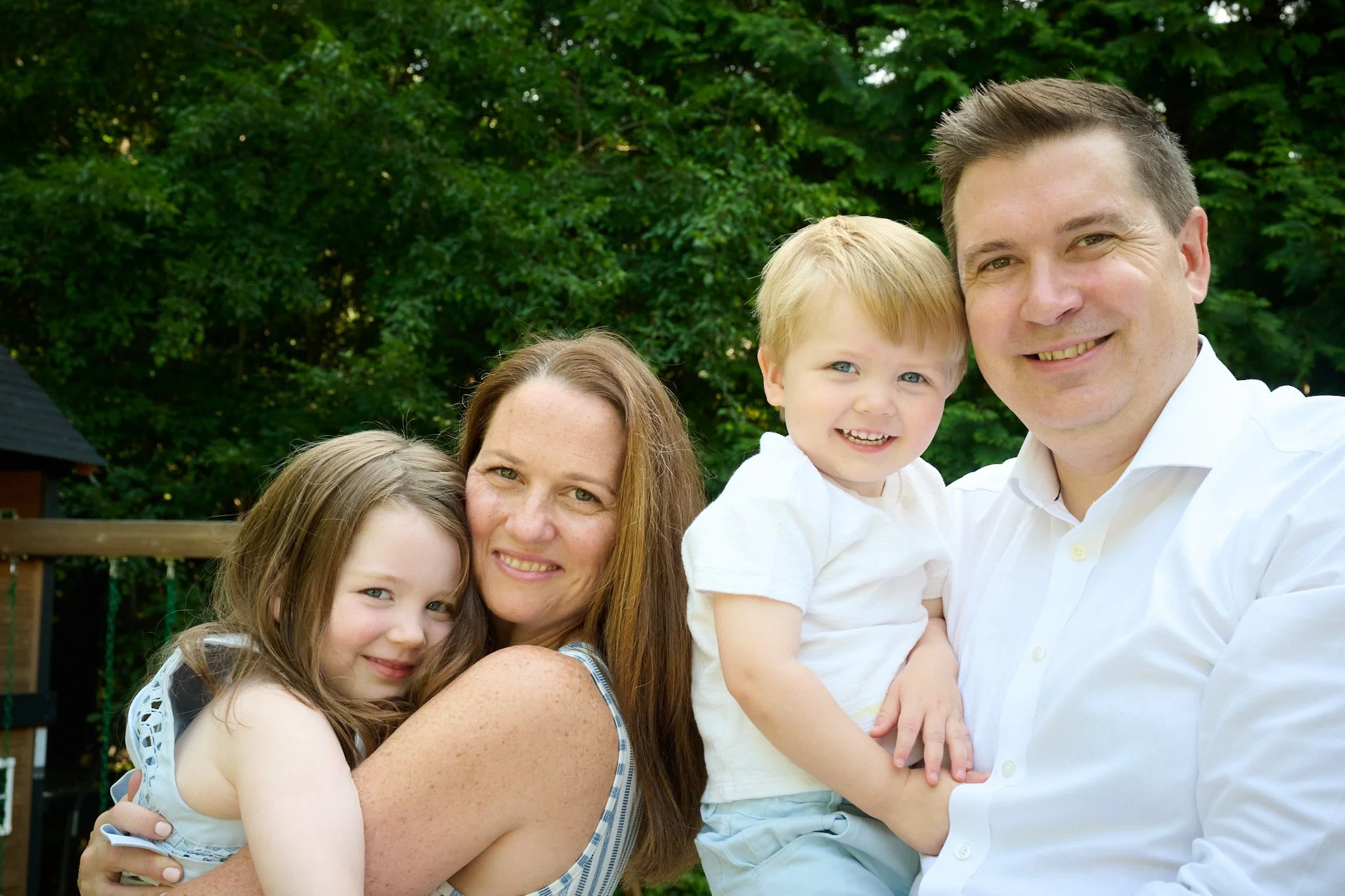 A young family poses for a portrait in the their Westport CT yard with lifestyle photographer Pamela Einarsen. 