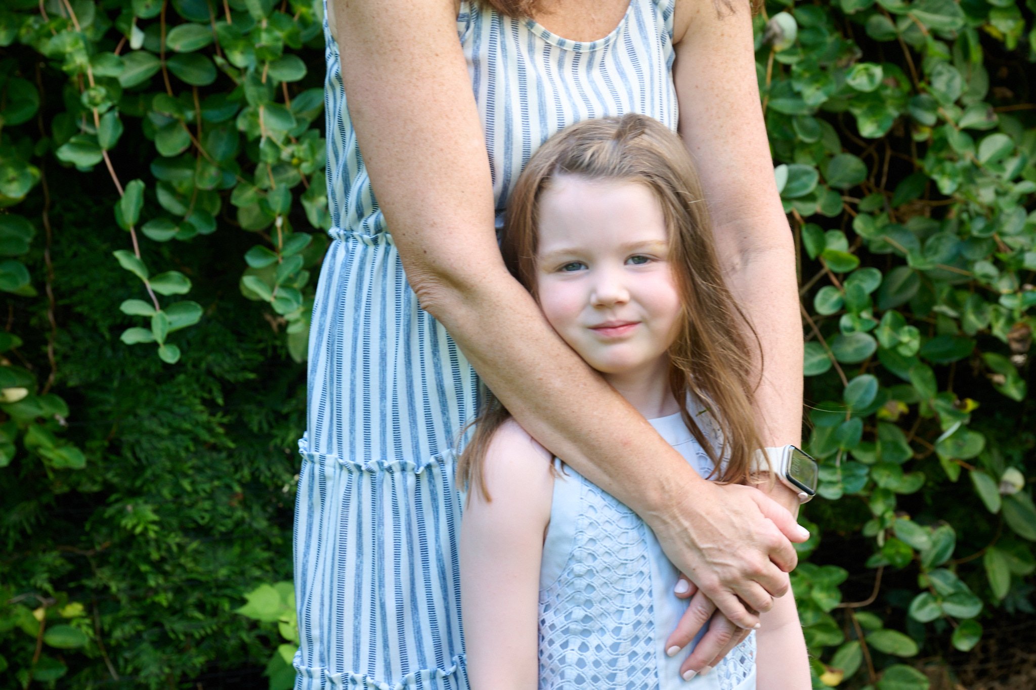 Mom warps arms around her young daughter in Fairfield County photo session with family photographer Pamela Einarsen.