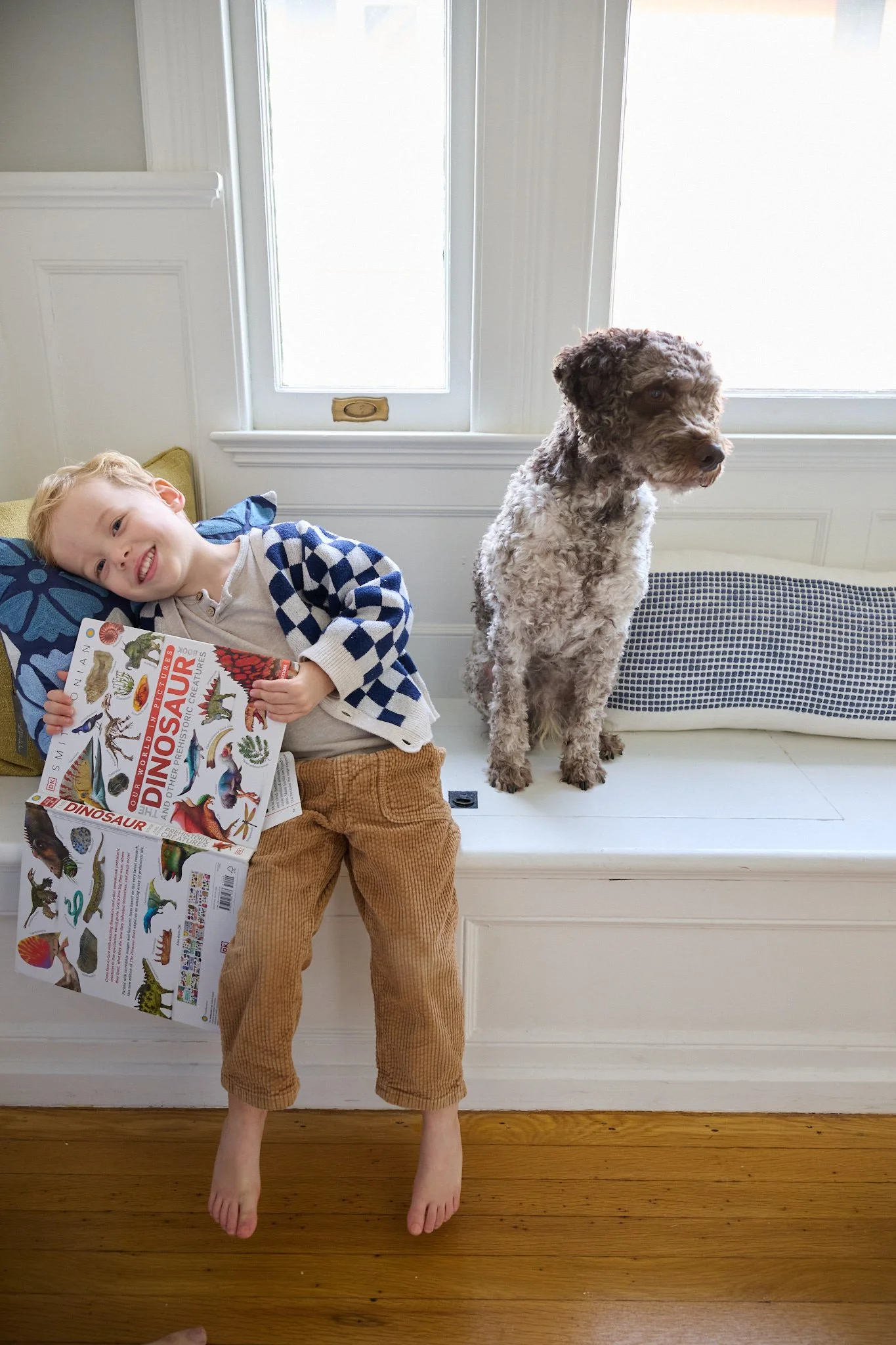 A boy sits his with his dog by a window in West Hartford, CT home by family photographer Pamela Einarsen.