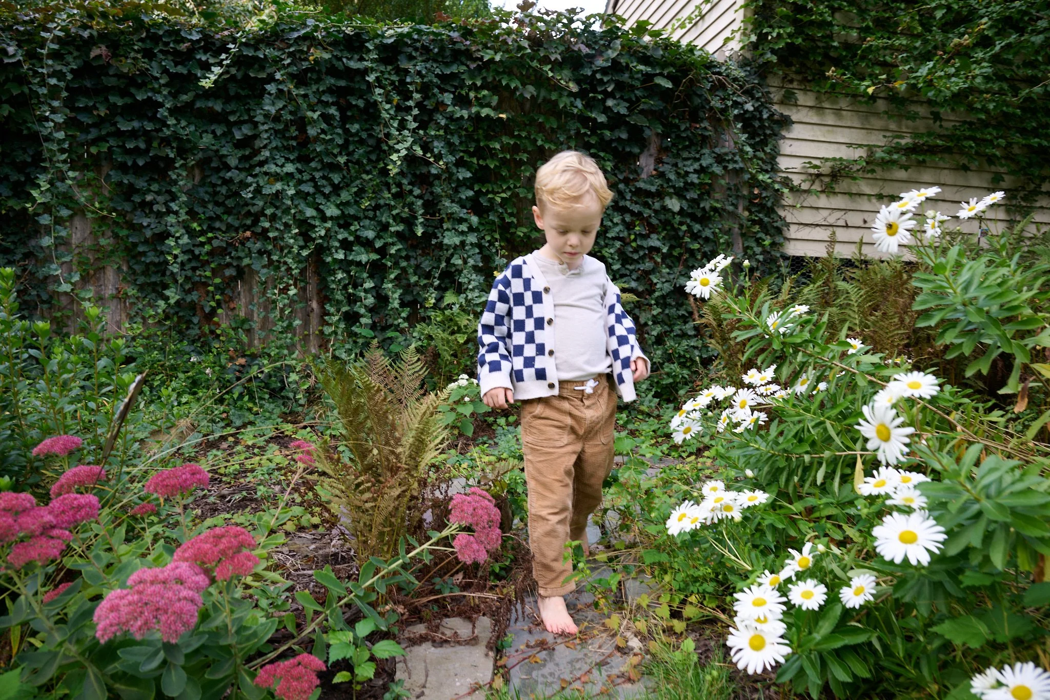 Young boy walks through the garden of his home in West Hartford, CT.