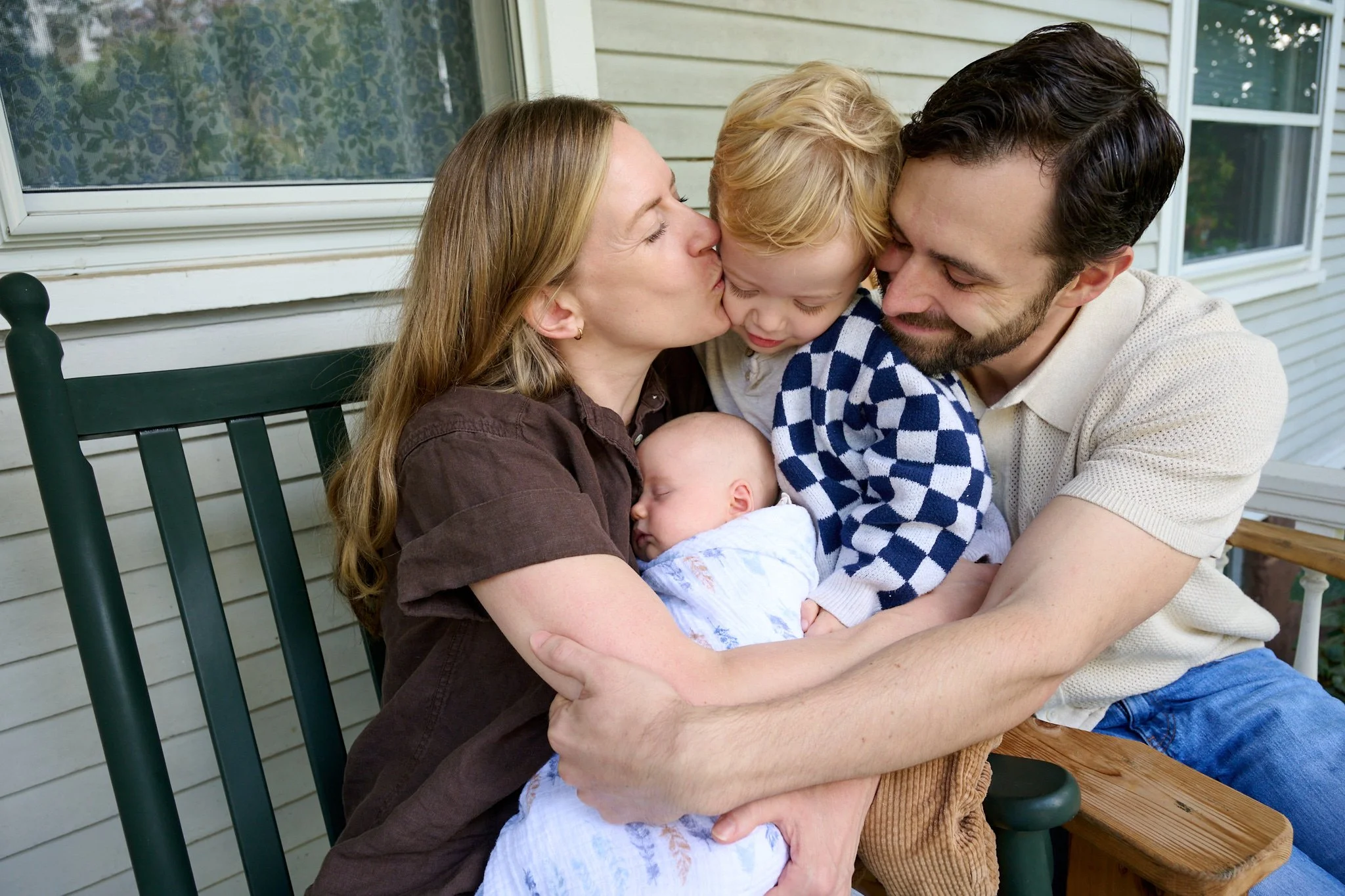 Family hugs each other on the porch in West Hartford, CT home by lifestyle photographer Pamela Einarsen. 