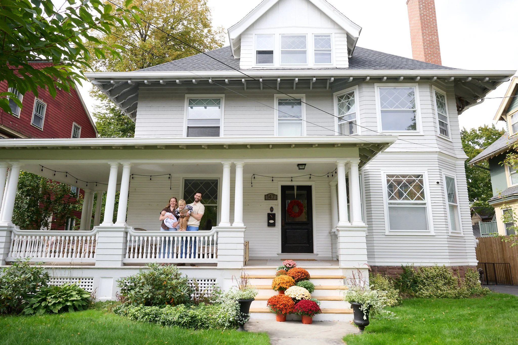 family poses on the porch of their Victorian West Hartford, CT home by family photographer Pamela Einarsen. 