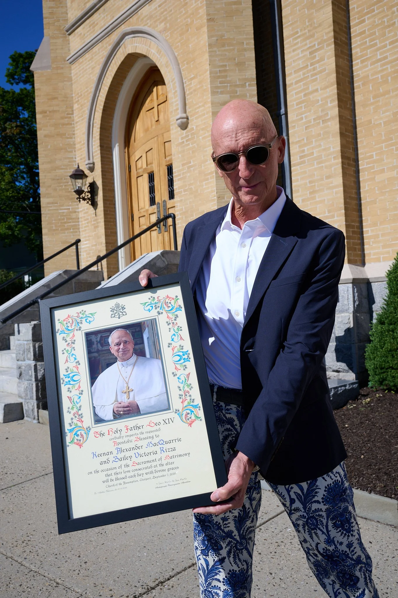 Man holds a signed blessing from the Pope at a wedding at Church of the Assumption in Westport, CT by event photographer Pamela Einarsen.