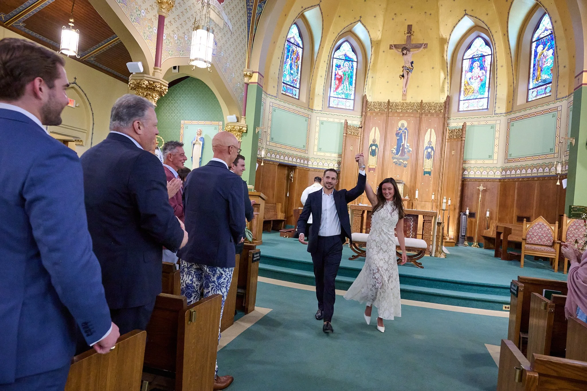 Husband and wife walk down aisle of Church of the Assumption in Westport, CT after getting married, by wedding photographer Pamela Einarsen. 