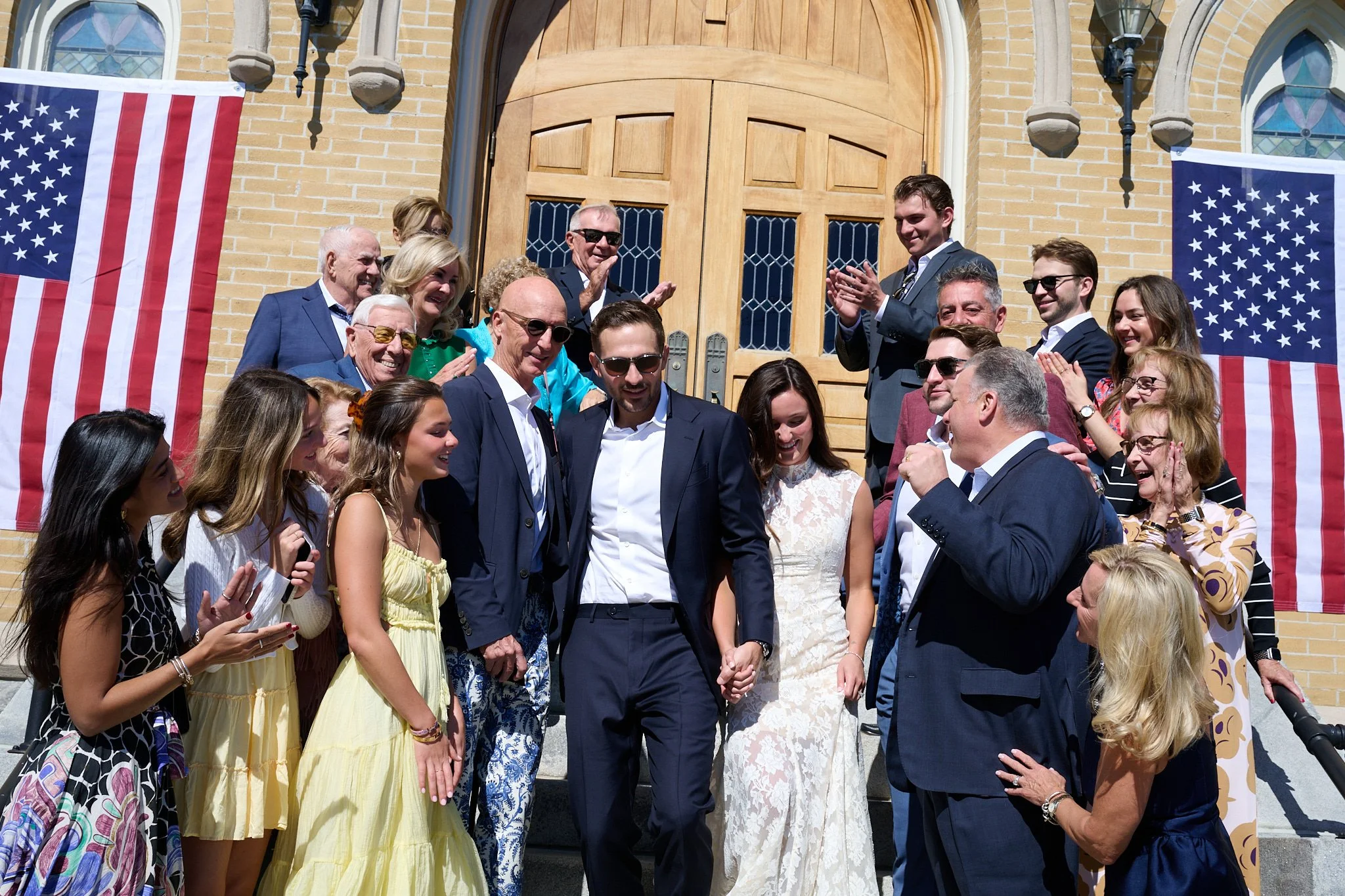 Family gathers around bridge and groom after wedding at hChurch of the Assumption in Westport, CT by wedding photographer Pamela Einarsen. 