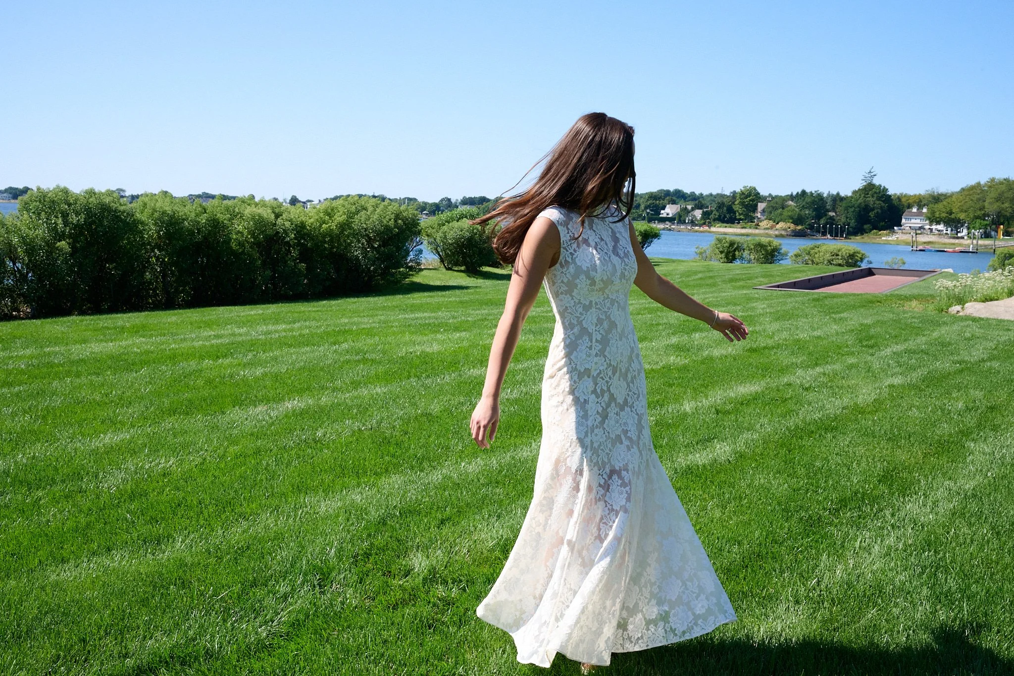 Bride dances in her wedding gown on the lawn in Westport, CT  by event photographer Pamela Einarsen. 