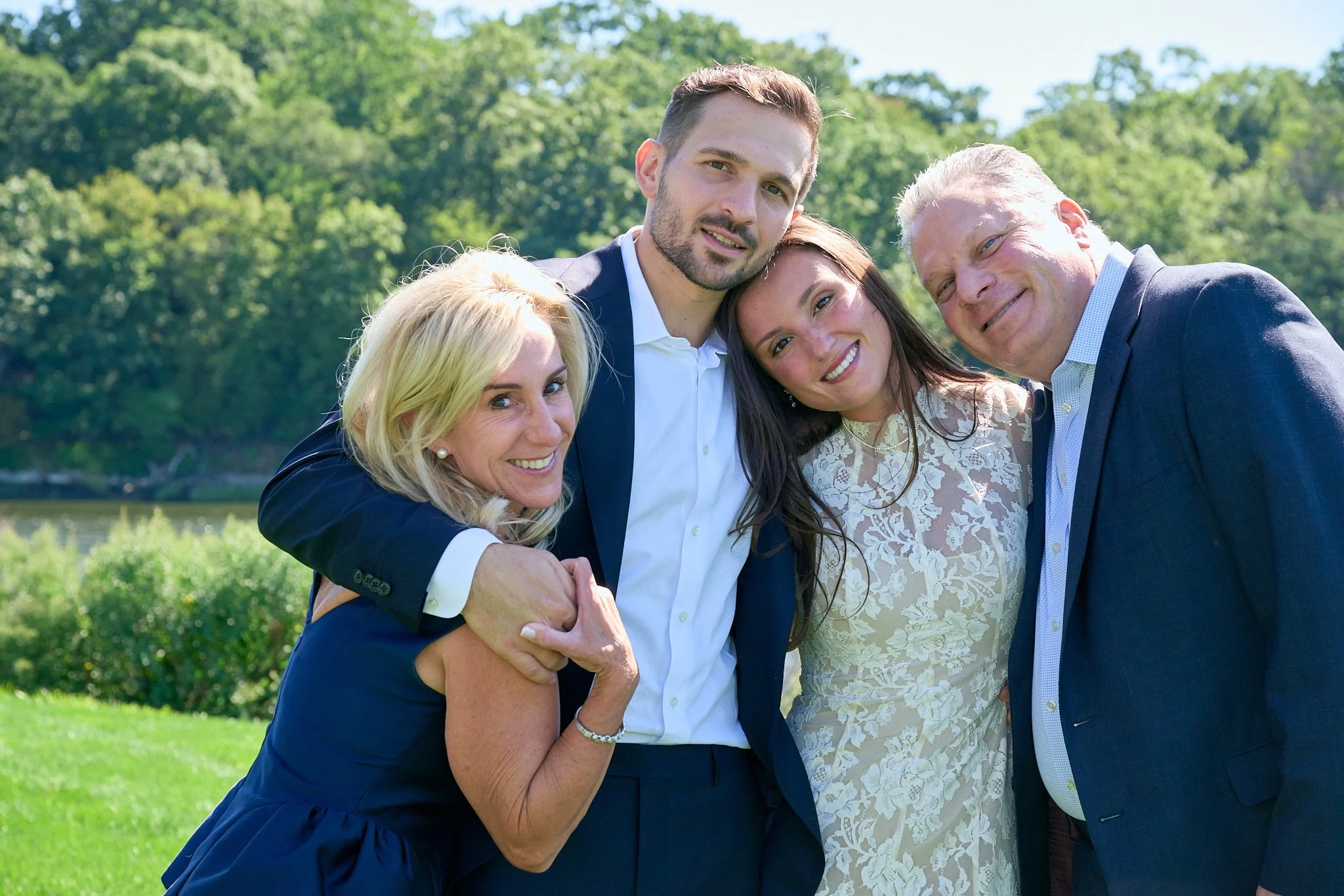 Bride and groom hug his parents at Westport CT wedding by event photographer Pamela Einarsen