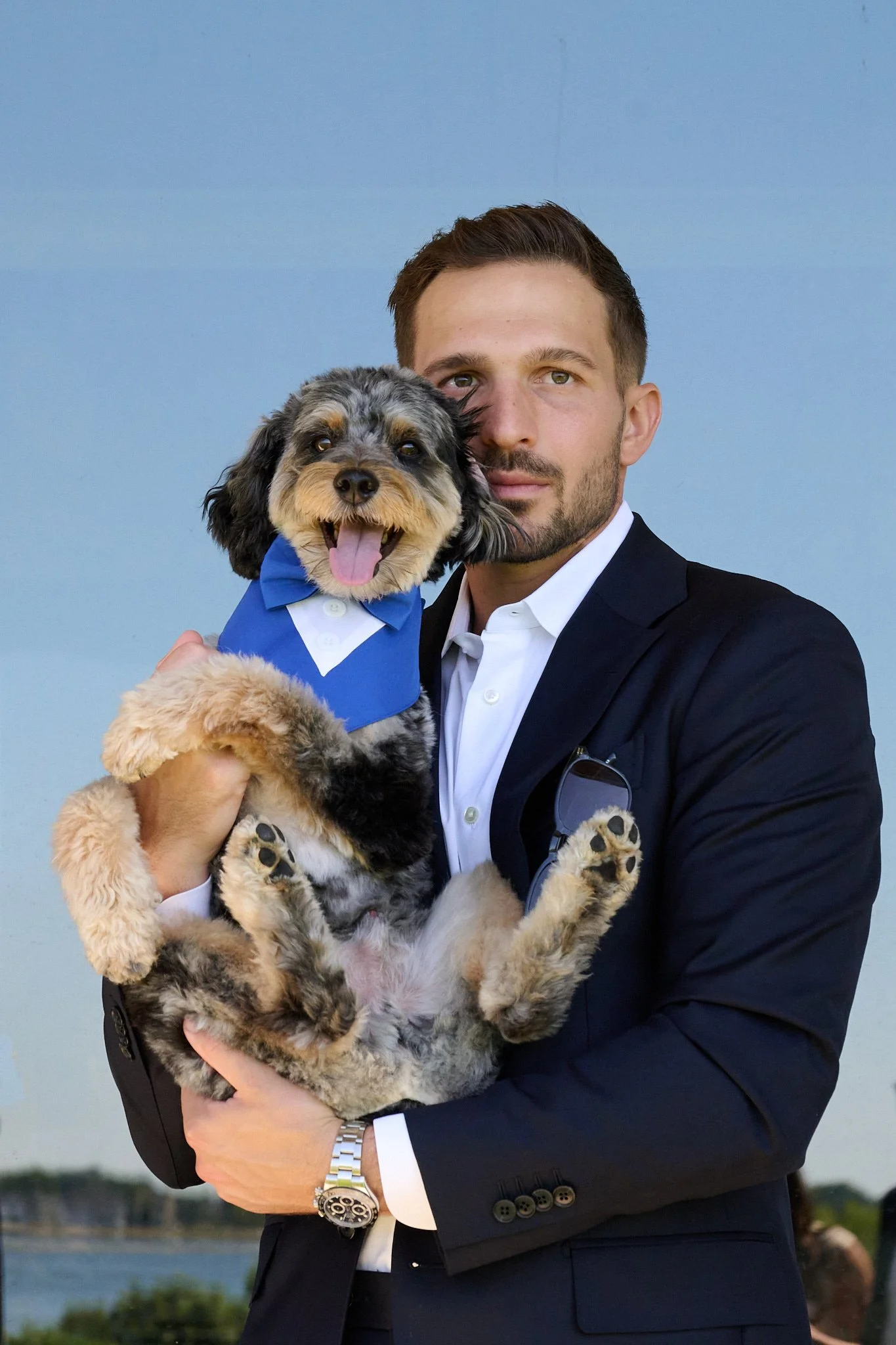 Groom cuddles his dog in a tuxedo at wedding in Westport CT by photographer Pamela Einarsen.
