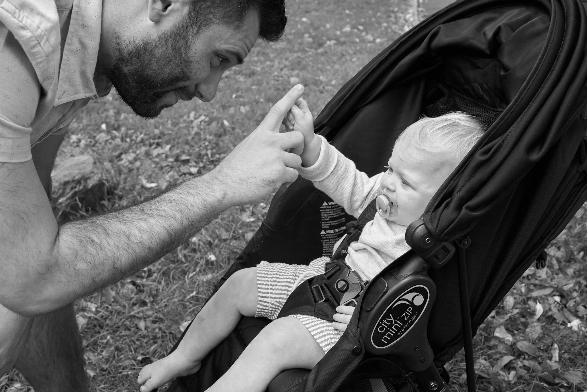 NYC baby plays with dad in a B&W lifestyle photo
