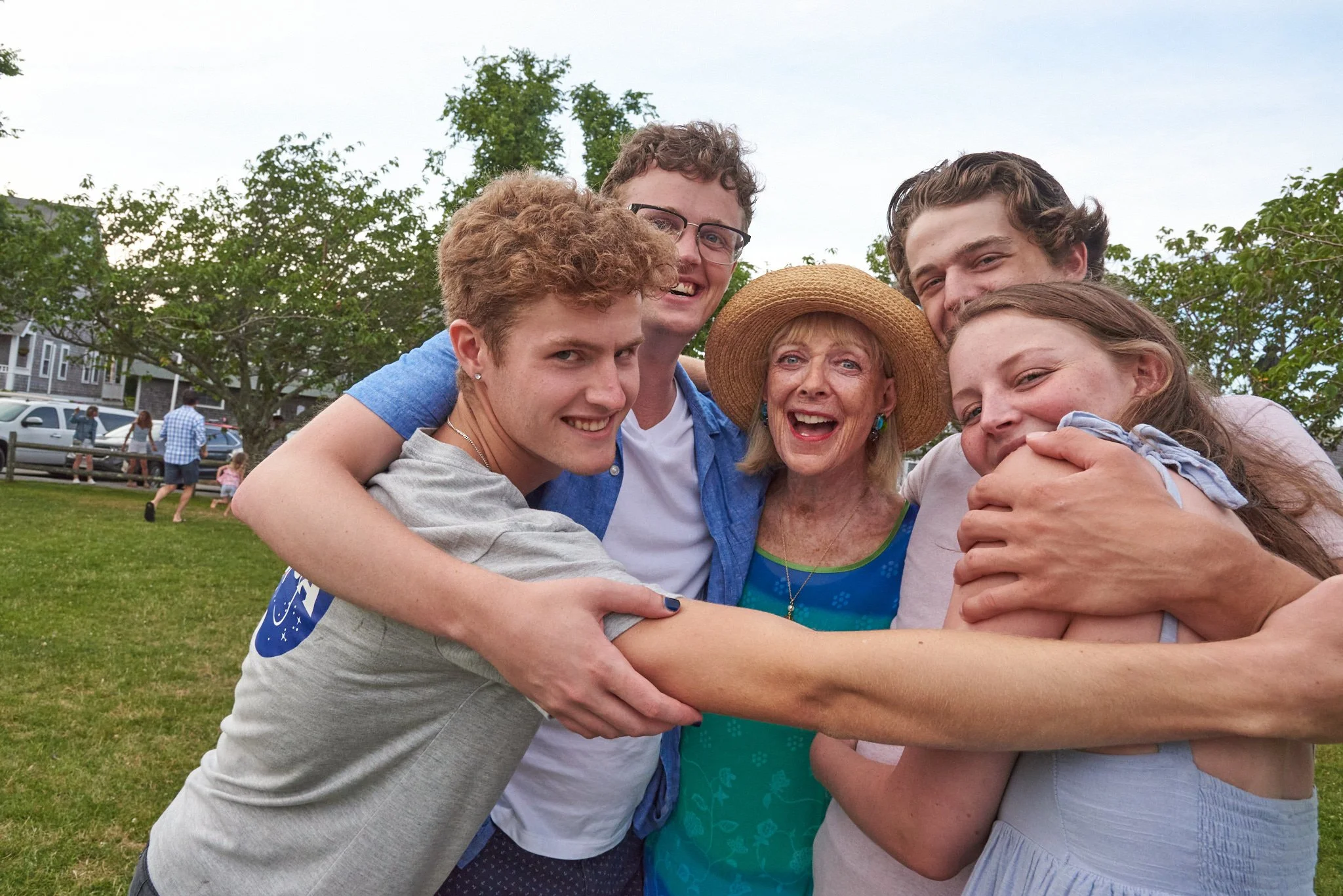 Grandmother hugs grandchildren during extended family reunion on Nantucket, MA