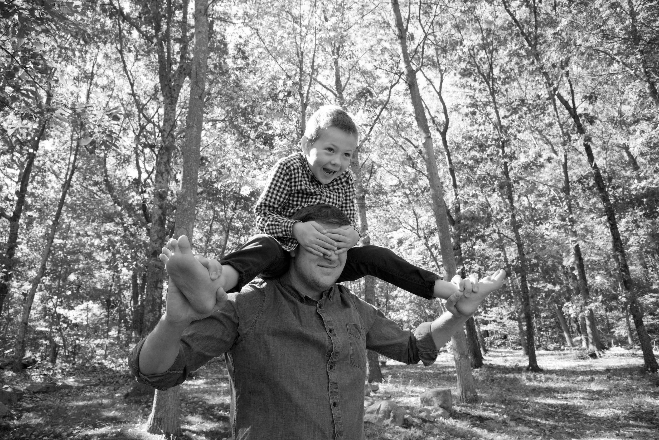 Father carries son on his shoulders at a family photo session with Pamela Einarsen in Easton CT.