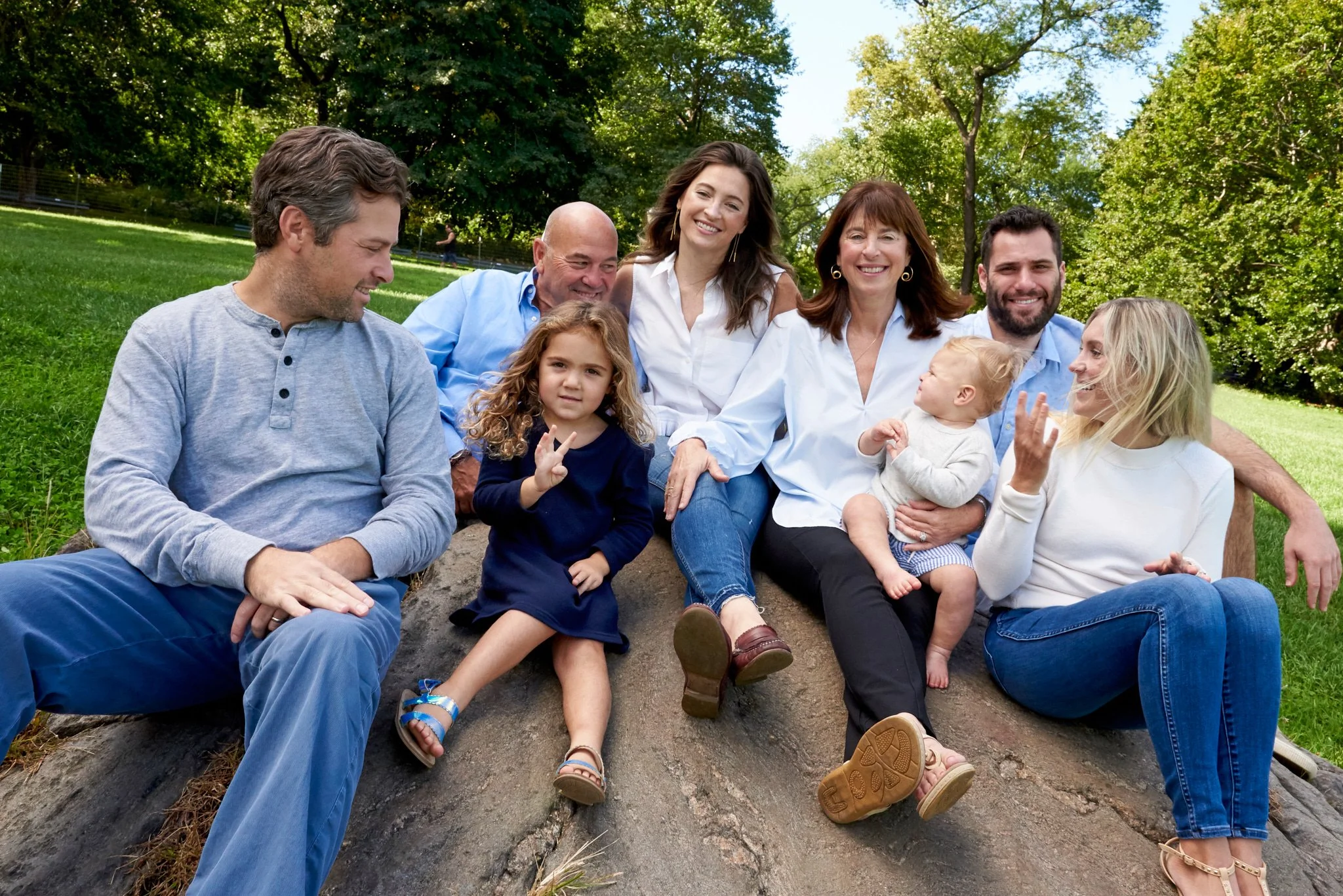 Extended family poses on rock in Central Park, New York City