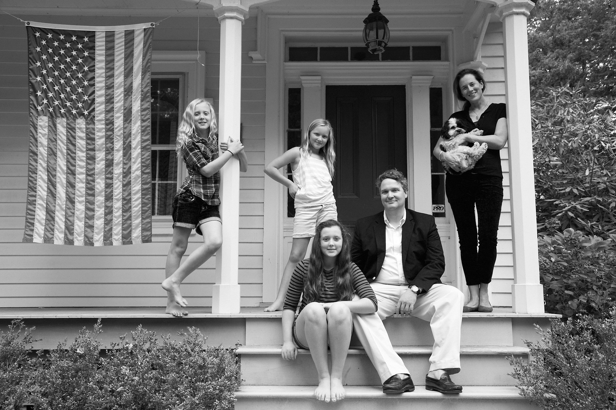 Family poses on their porch in Greenwich, CT by photographer Pamela Einarsen.