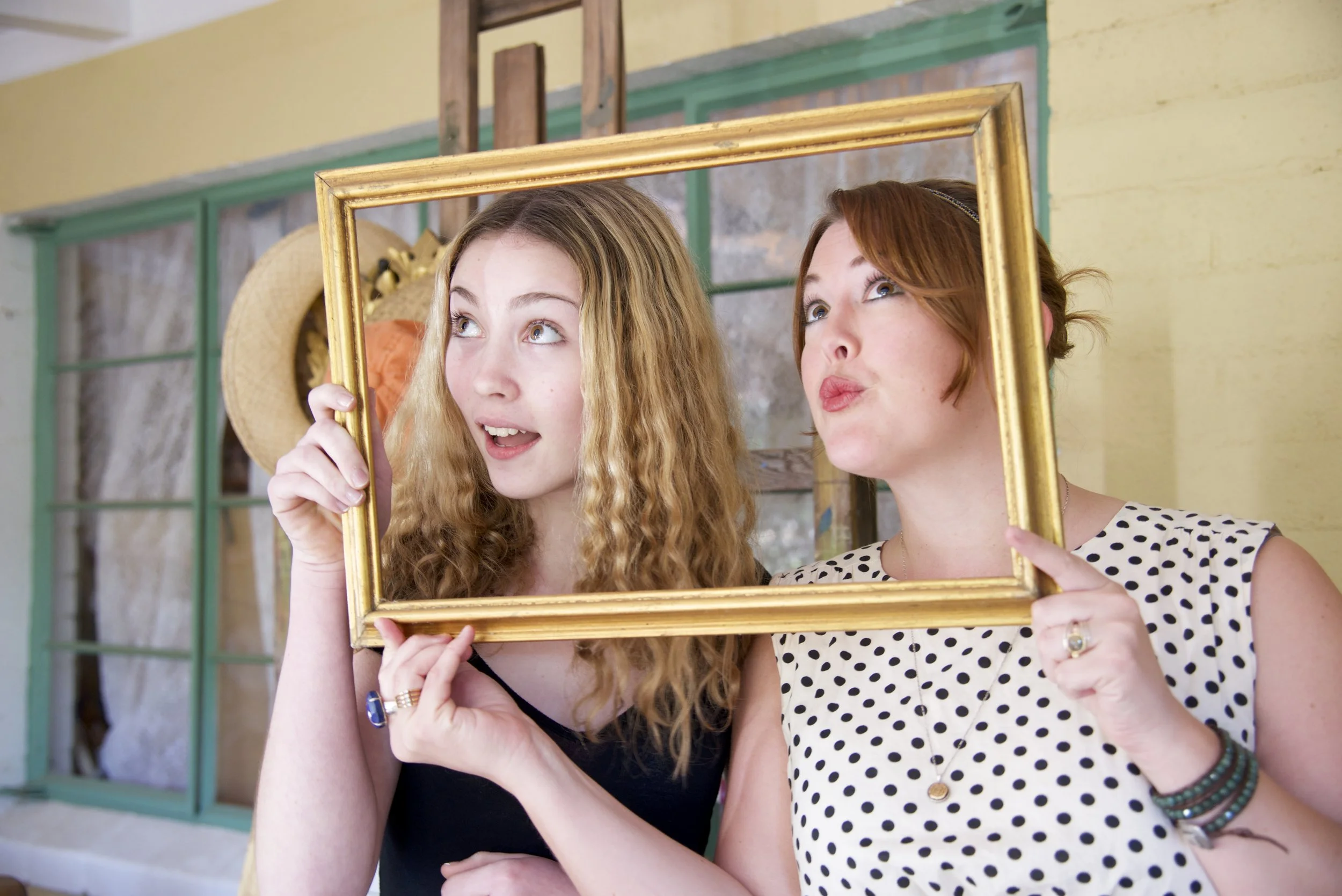 Family poses behind a frame in Ojai photographer session