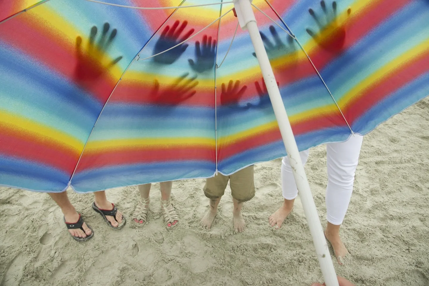 Family places hands on beach umbrella in Kiawah