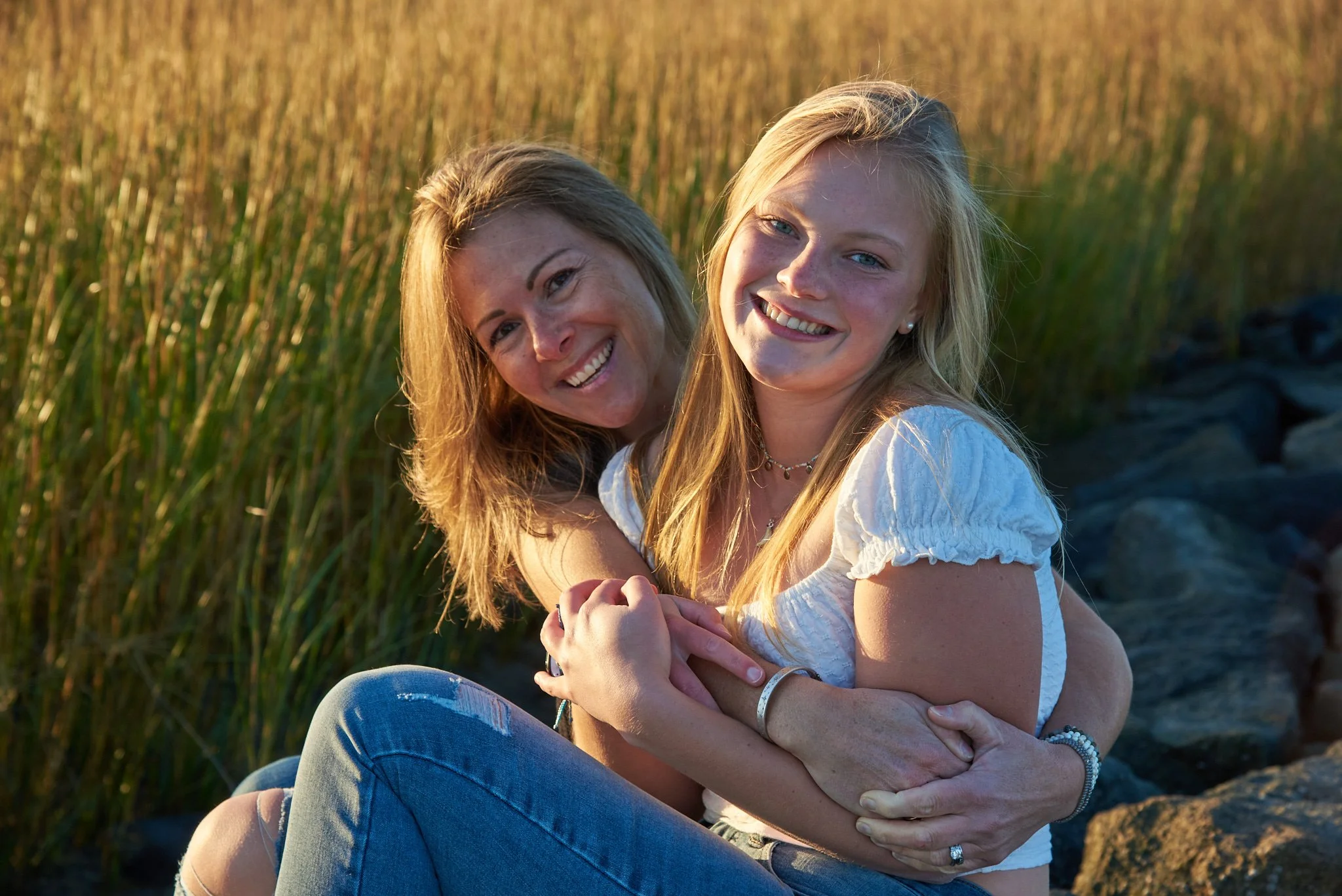 Mother hugs daughter at Southport beach at sunset