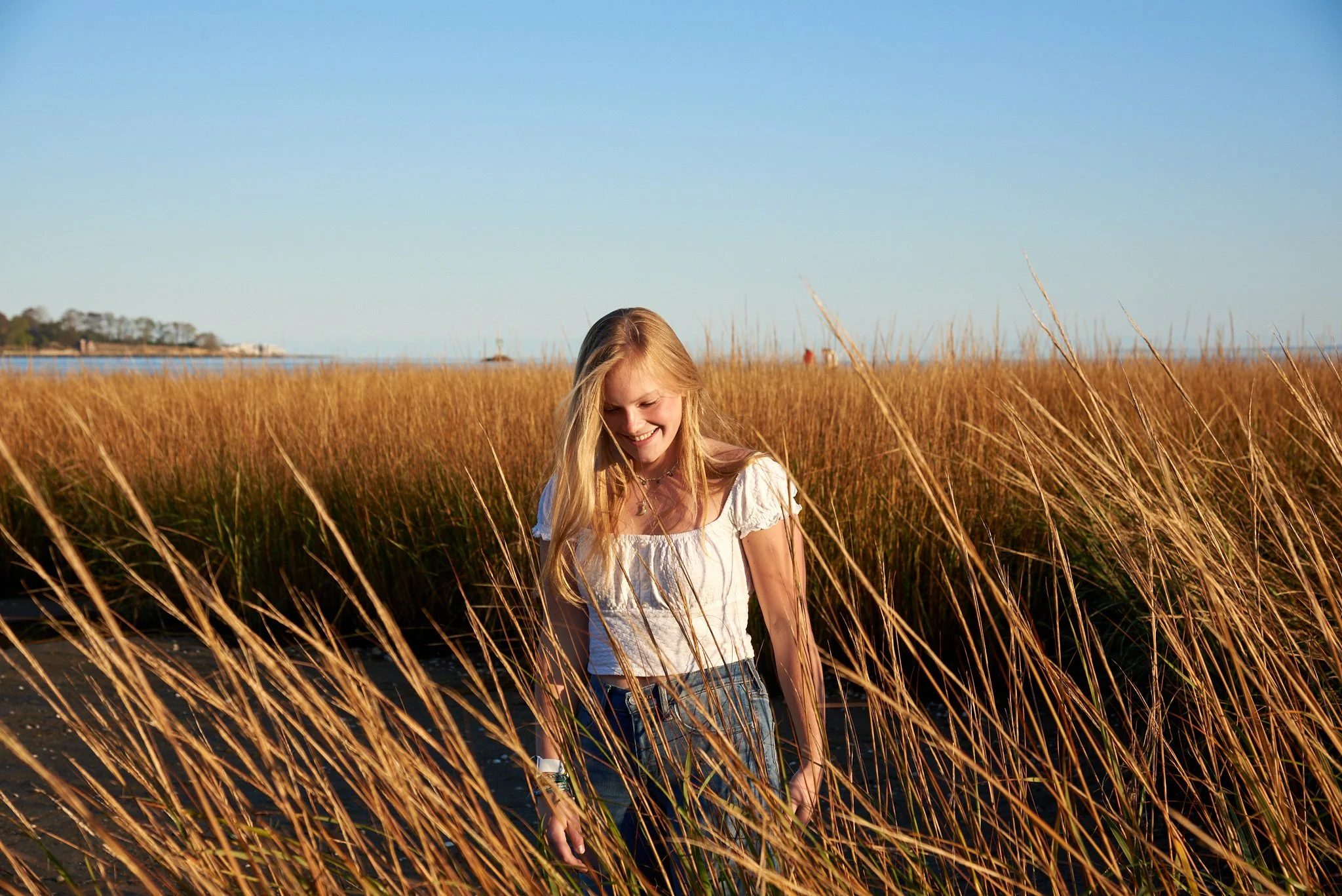 Woman stands in the marsh grasses near Southport Harbor — one of the towns Pamela Einarsen photographs across Fairfield County