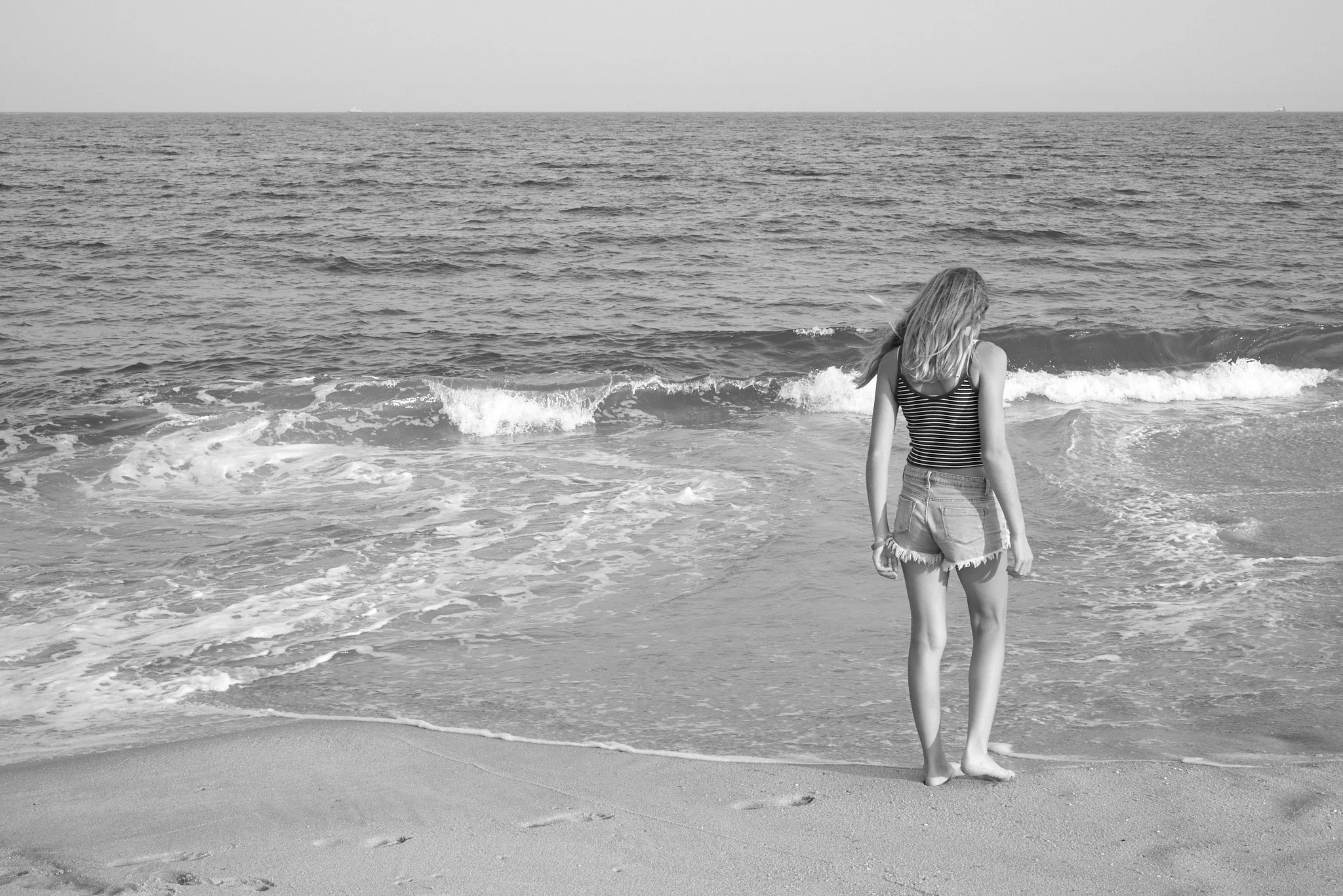 Teenage girl walks along the New Jersey shore for candid photographer