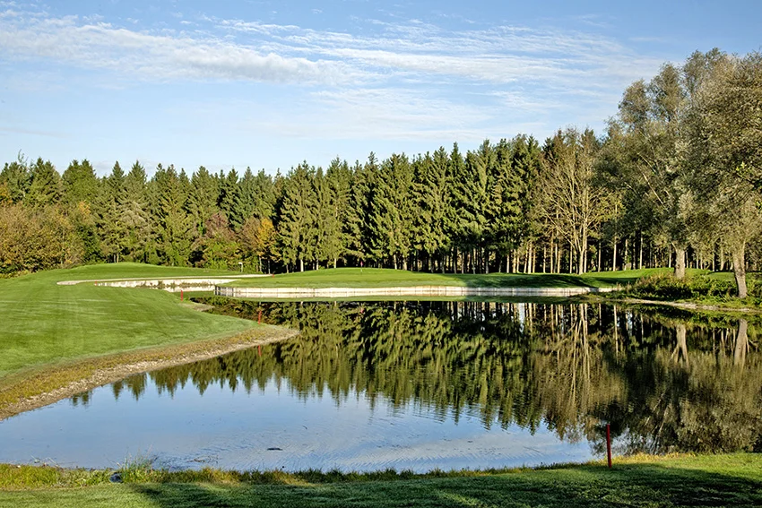The 3rd hole at Eichenried is flanked by water and trees.