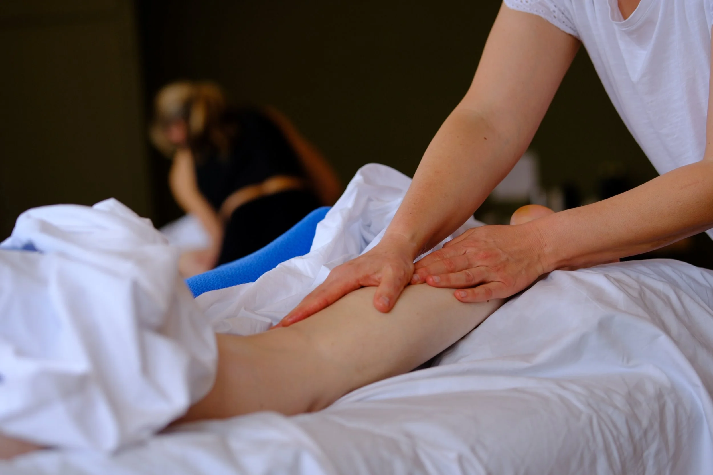 Teilnehmerin übt die Massage des Unterschenkels in einem Esalen Massage Einführungskurs.