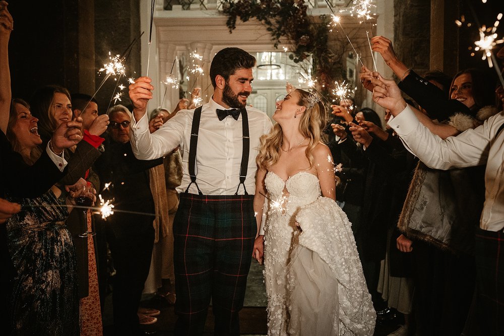 bride and groom with sparklers outside drumtochty castle for their dream Scottish destination wedding