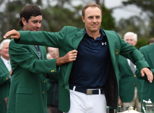 Bubba Watson places the Green Jacket on 2015 Champion Jordan Spieth at the 79th Masters Golf Tournament. (Photo Cred: Don Emmert/AFP)