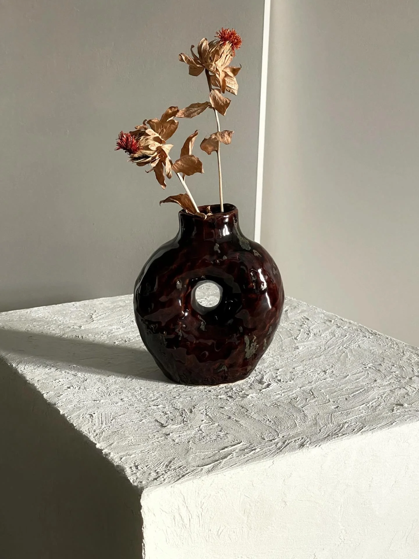 Small vase handmade in a white stoneware clay mixed with volcanic rocks dipped in a delicious tenmoku glaze