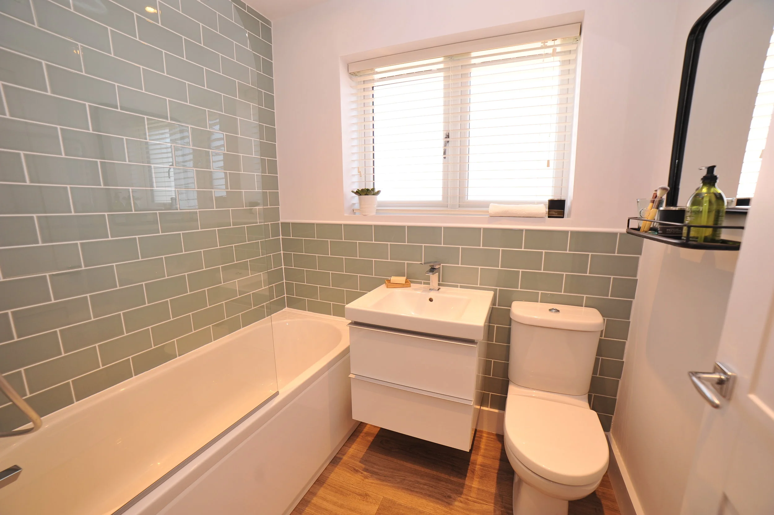Fresh bathroom with green metro tiles and white walls. 