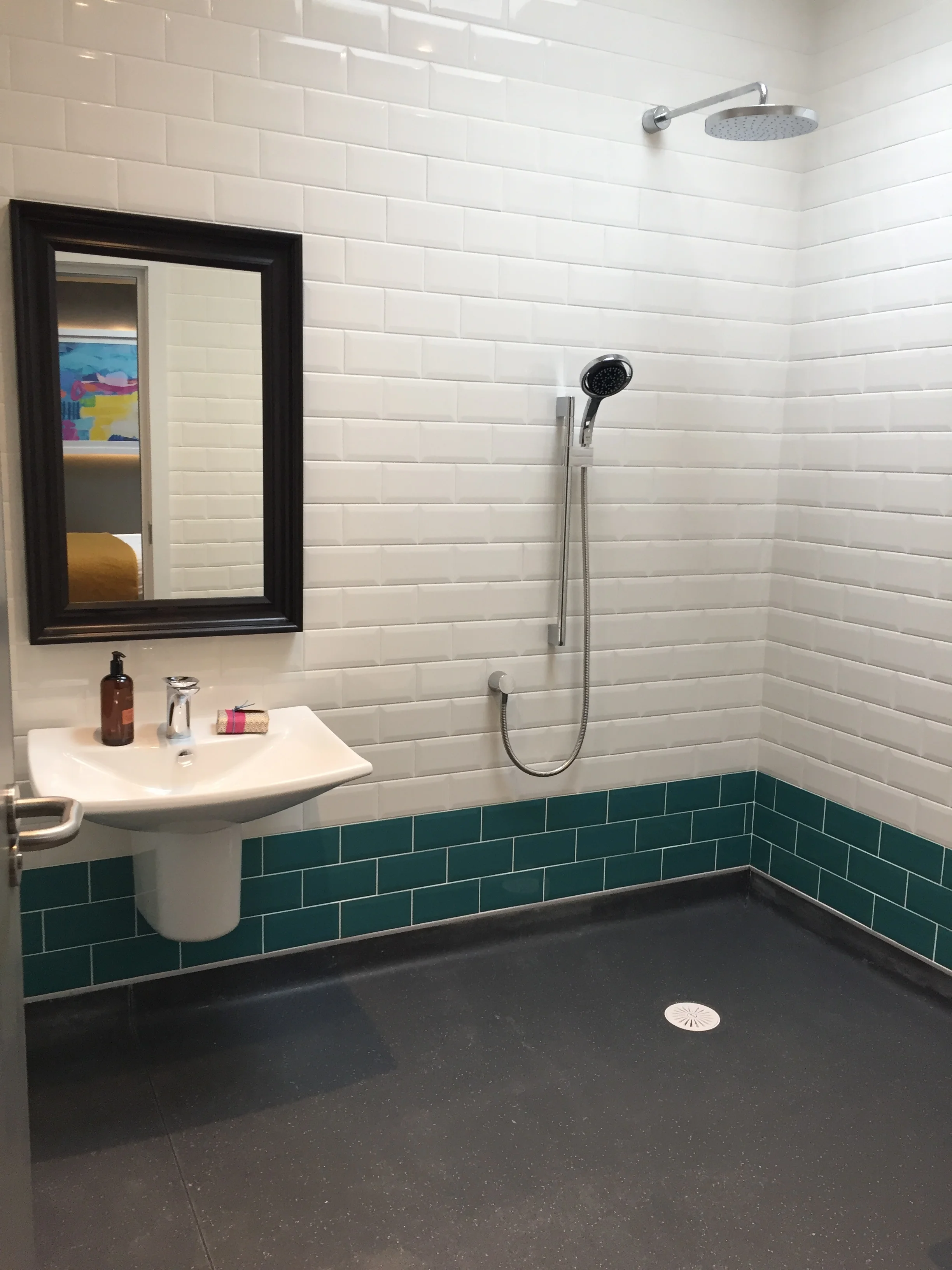 Victorian style wet room with three teal metro tiles at the bottom of the wall and white metro tiles above.