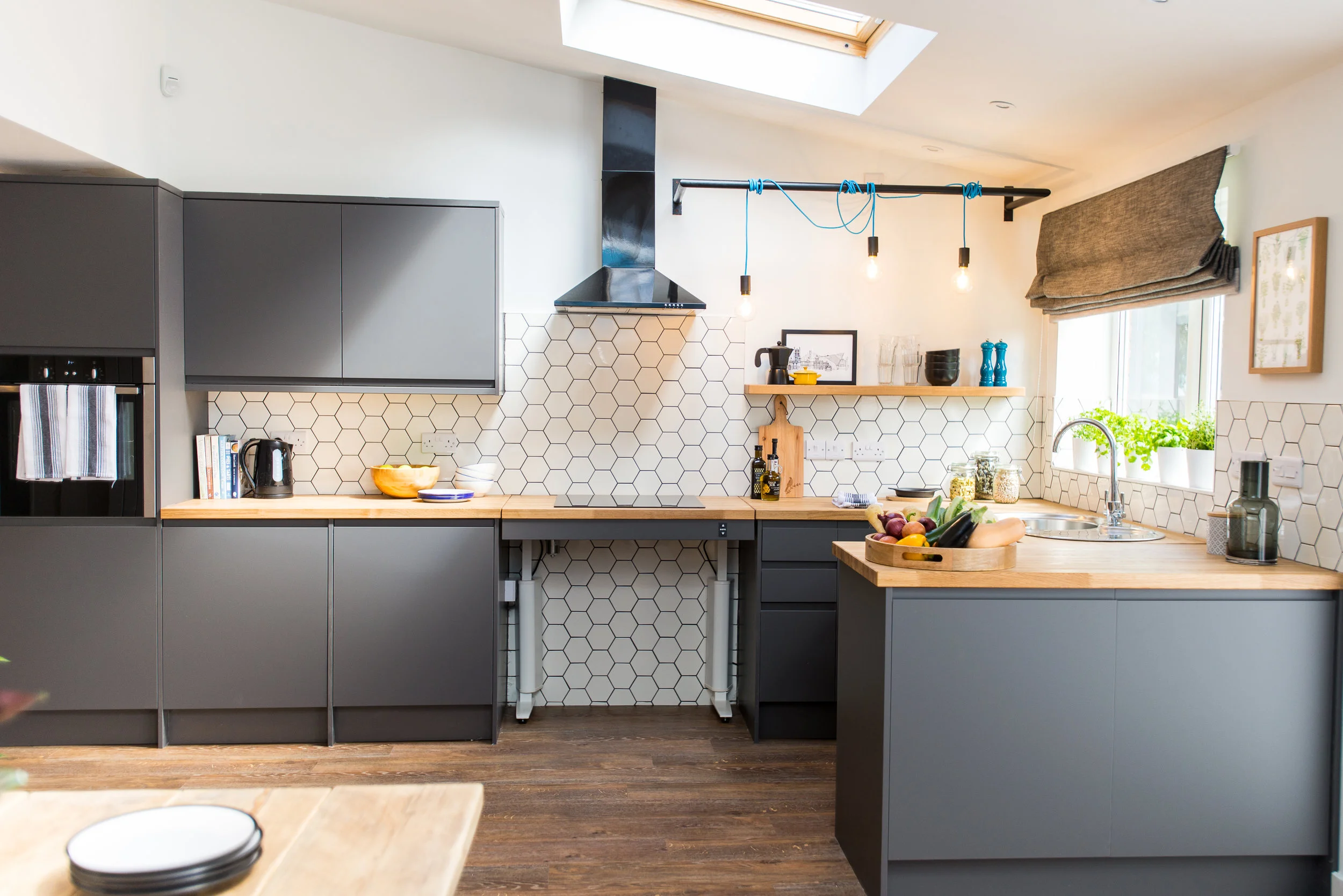 Anthracite handless kitchen with oak worktop and white hexagonal tiles