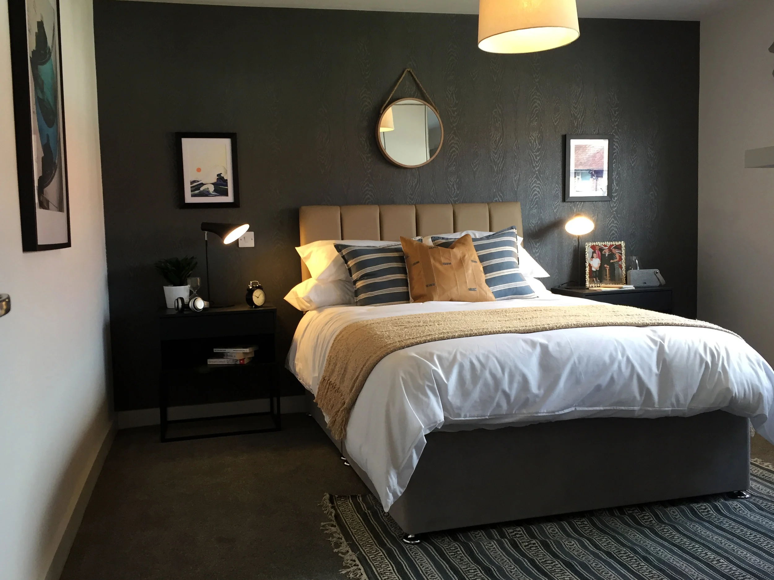 Monochrome bedroom with leather headboard and feature wallpaper