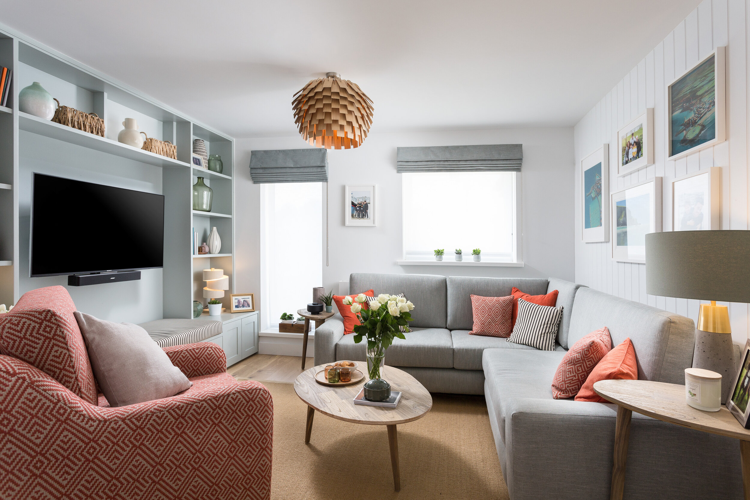 Bright coastal style living room with blue and orange accents in the soft furnishings