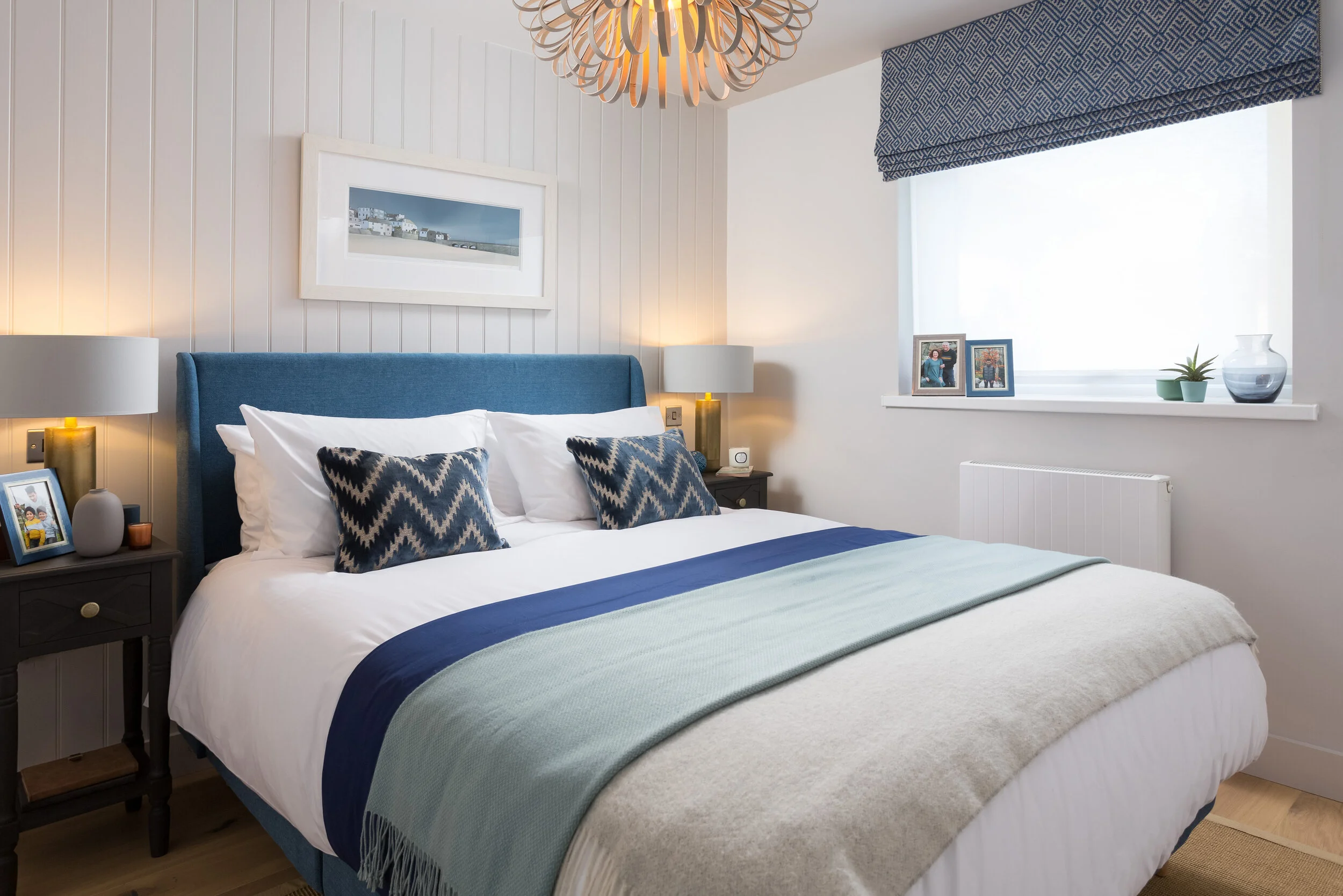 Off white master bedroom with tongue and groove feature wall and a blue upholstered bed