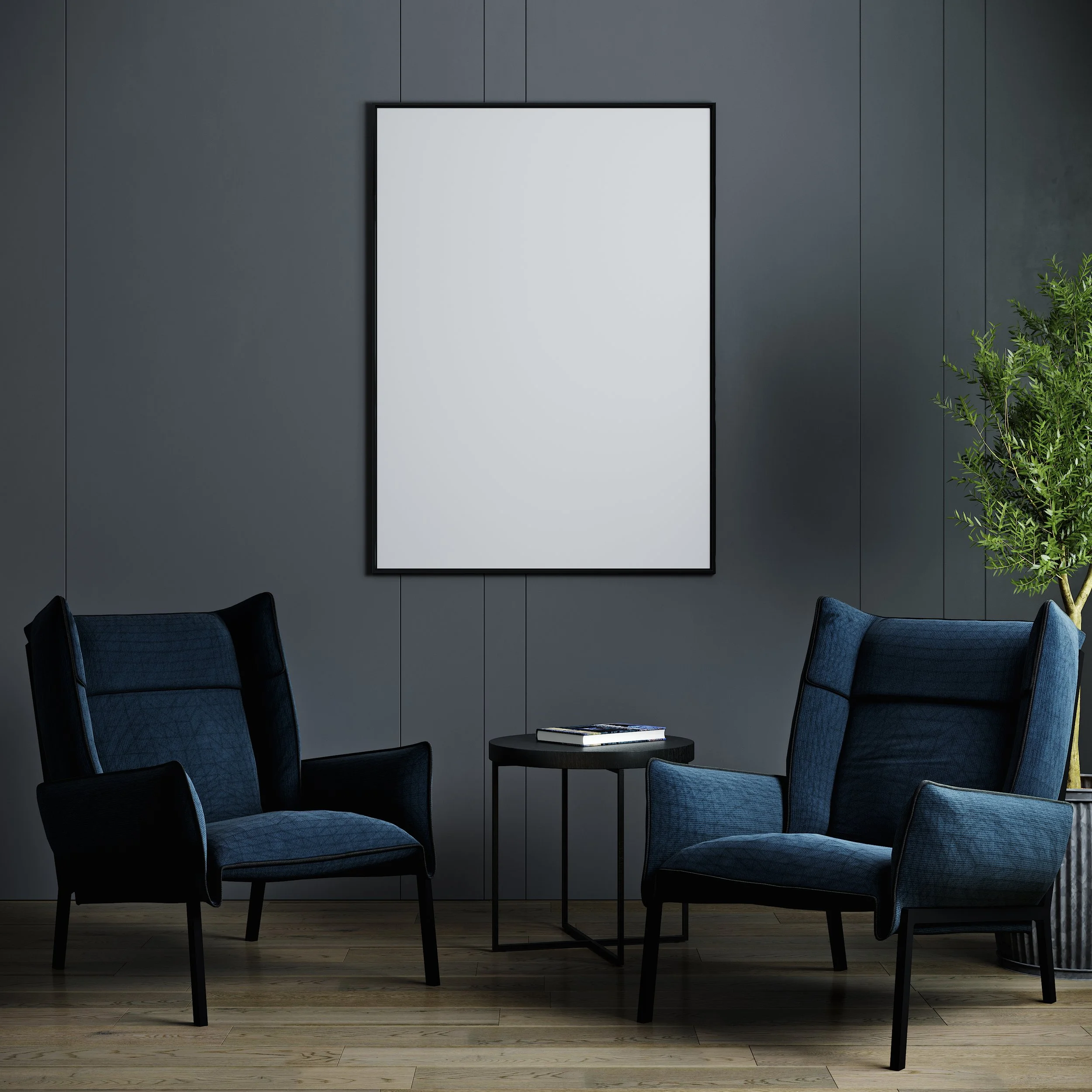 A plain 24 x 36 poster frame against a modern grey wall with two blue armchairs.