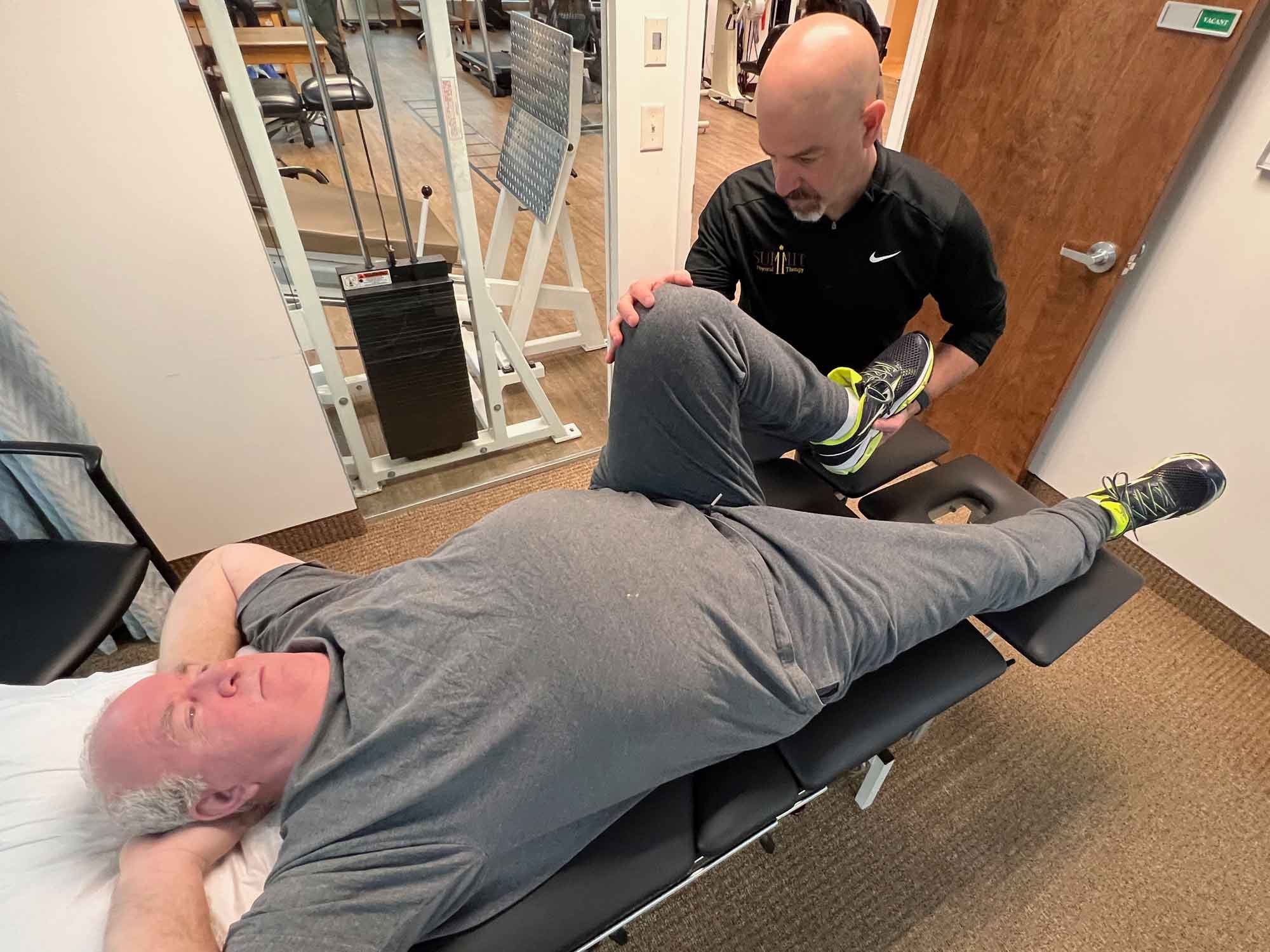  A therapist works with his patient on knee mobility. 
