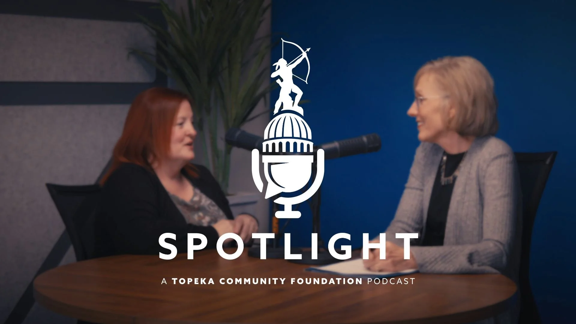 Marsha Pope and Jamie Jalil are sitting at a table and talking to each other. The Spotlight podcast logo is centered on the photo.