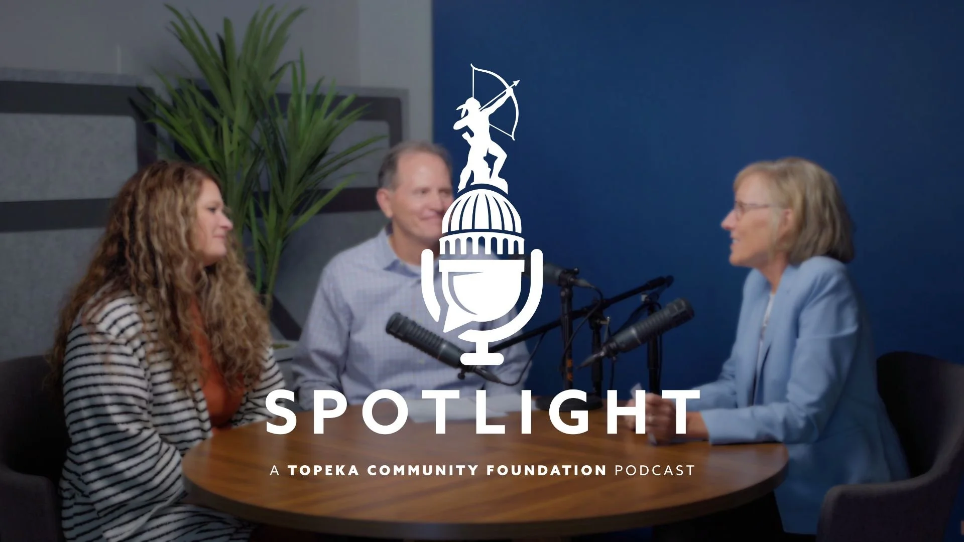 Marsha Pope, Keith Warta, and Erin Steele are sitting around a table and talking to each other. The Spotlight podcast logo is centered on the photo.