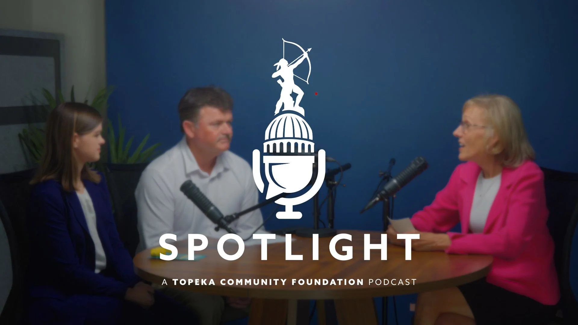 Marsha Pope, Dr. David Price, and Emily Harmon sit around a table talking with each other. The Spotlight podcast logo is centered on the photo.