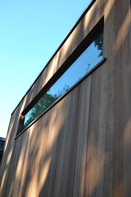 South face of cabin, with 20 x 120" window, sited high for sunlight and privacy.