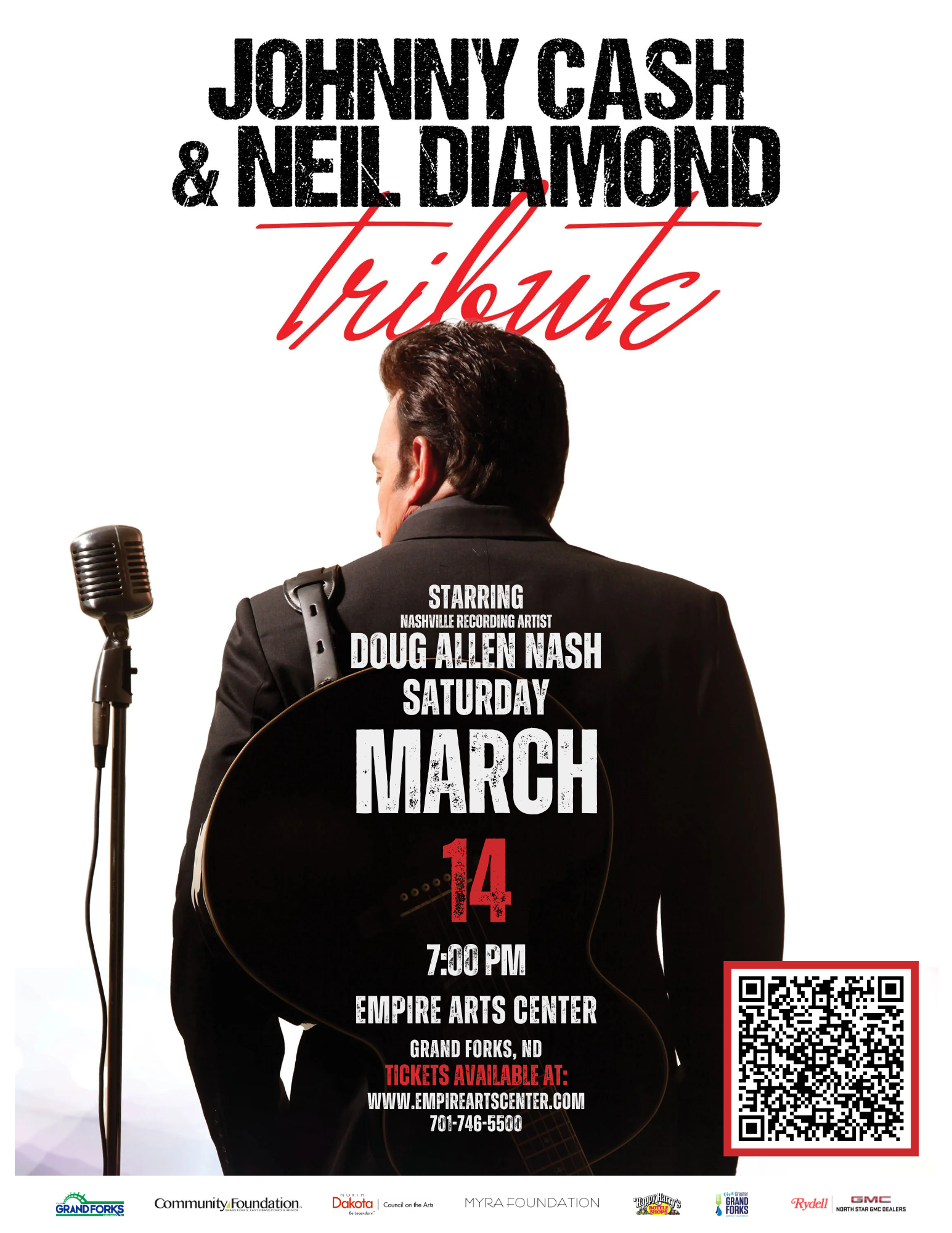 Doug Allen Nash Looking back at a microphone, guitar slung behind his back