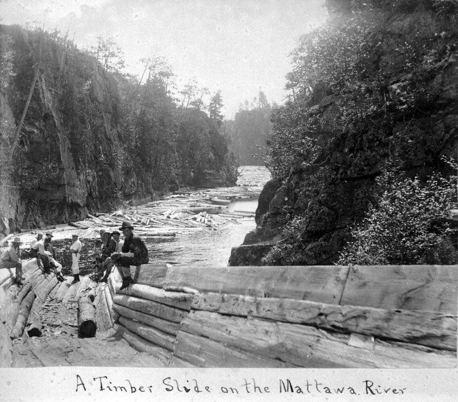 Hommes assis sur une glissoire de bois sur la rivière Mattawa, 1897
