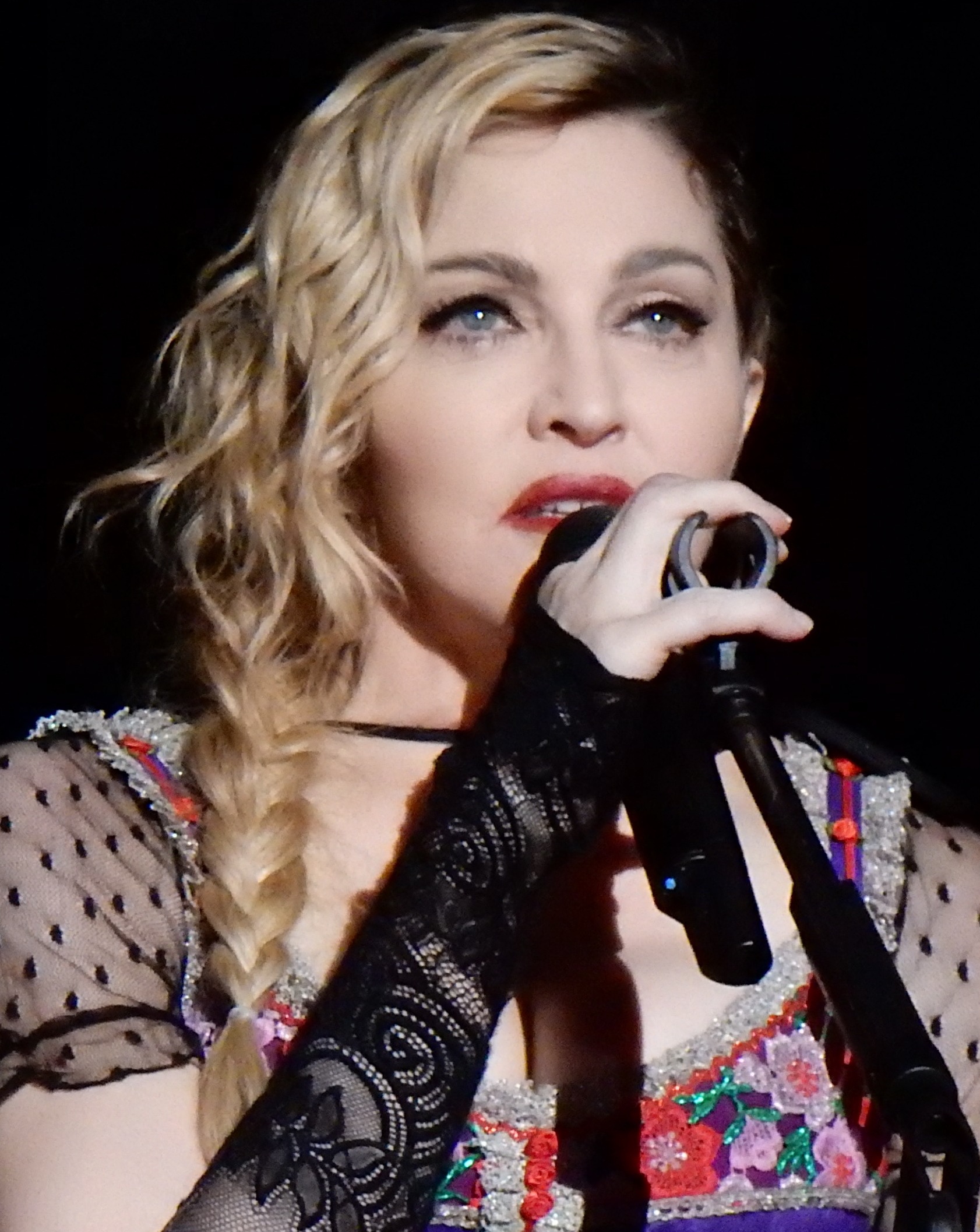 Madonna à Stockholm en 2015 (source: "Madonna Rebel Heart Tour 2015 - Stockholm", image numérique d’une photo de 2015 par l’auteur Wikipedia chrisweger, Wikimedia Commons ( https://commons.wikimedia.org )).