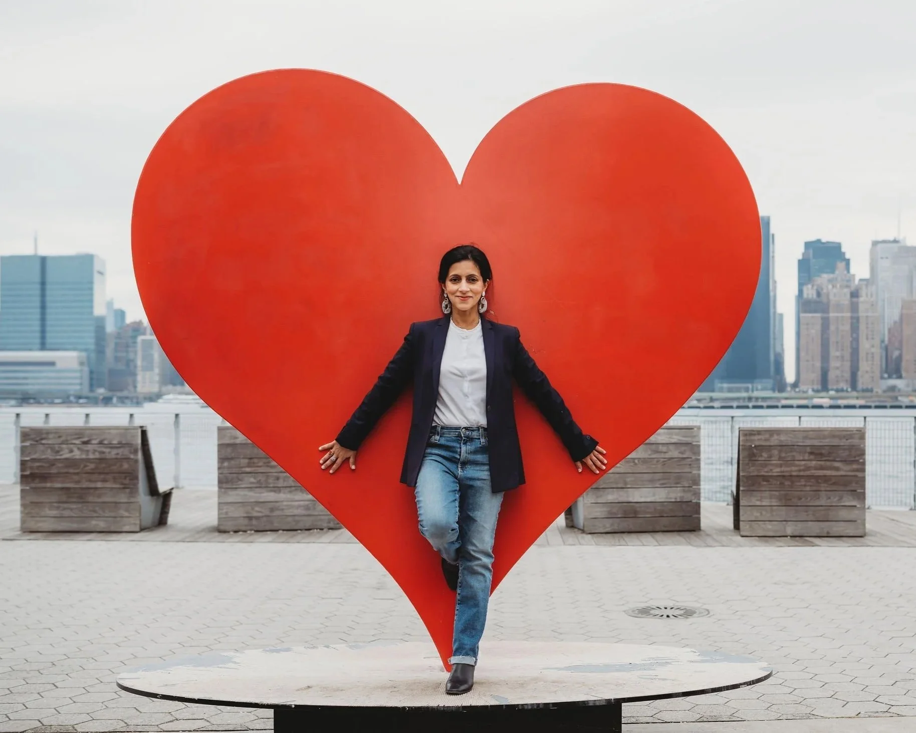 Mansi Narang standing in on a platform in front of a life size heart