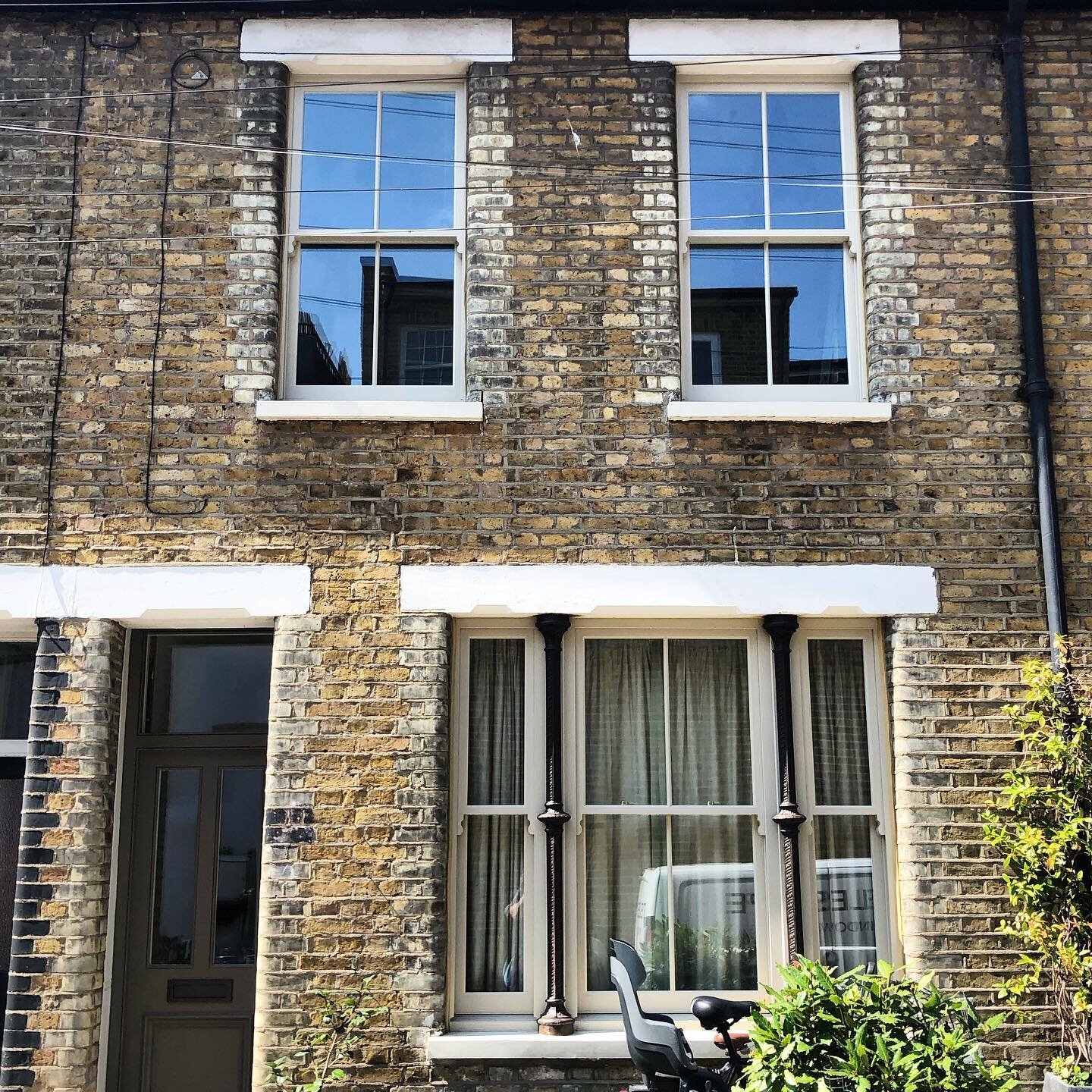 Handsome newly fitted windows in the cute terrace . Frames and glass washed to a sheen