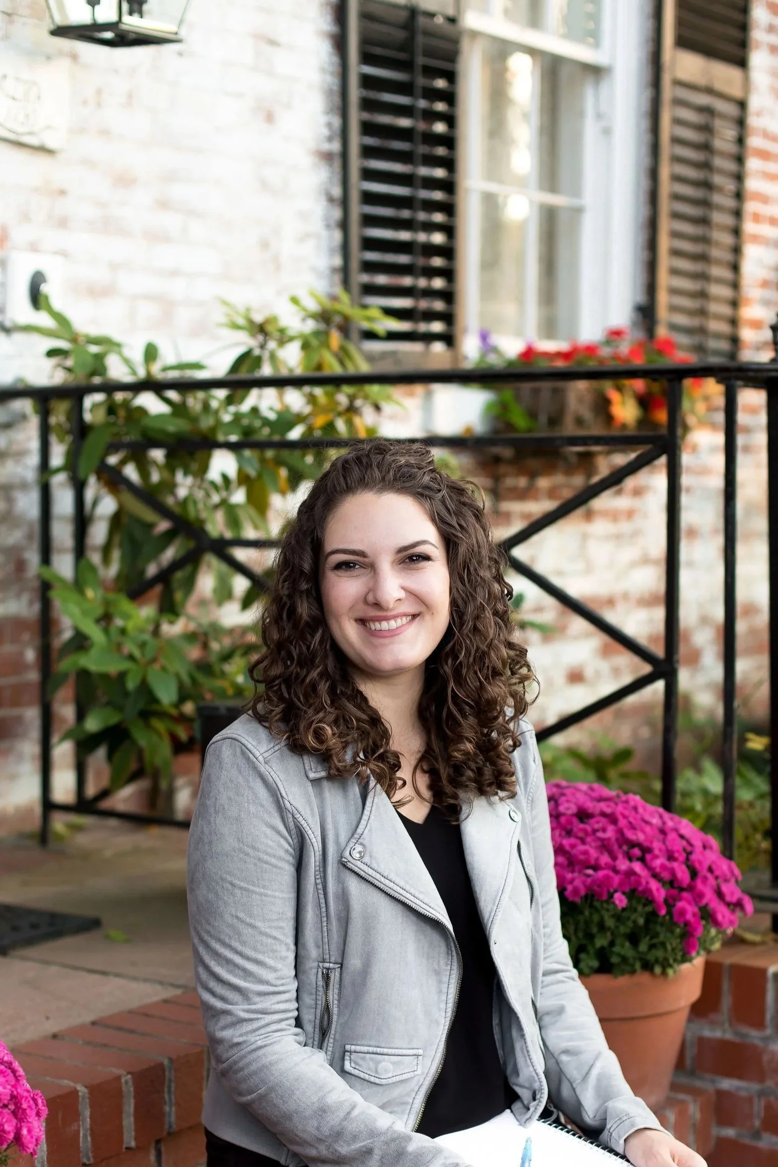 Brittany Schnurr, LMFT therapist in Fairfax, VA sitting outside with colorful foliage looking warm and approachable.