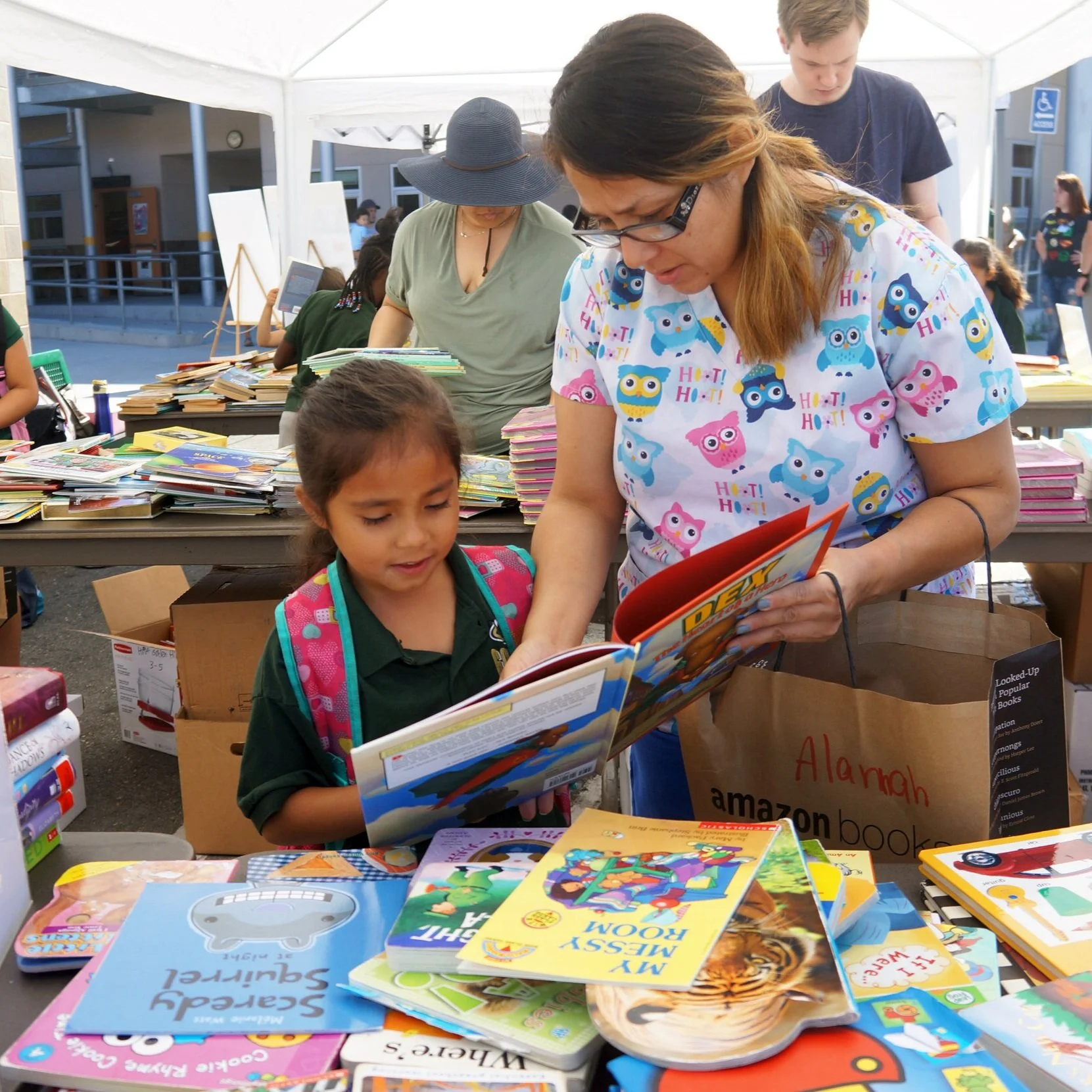 Photo of a Woman and Girl Browsing Books