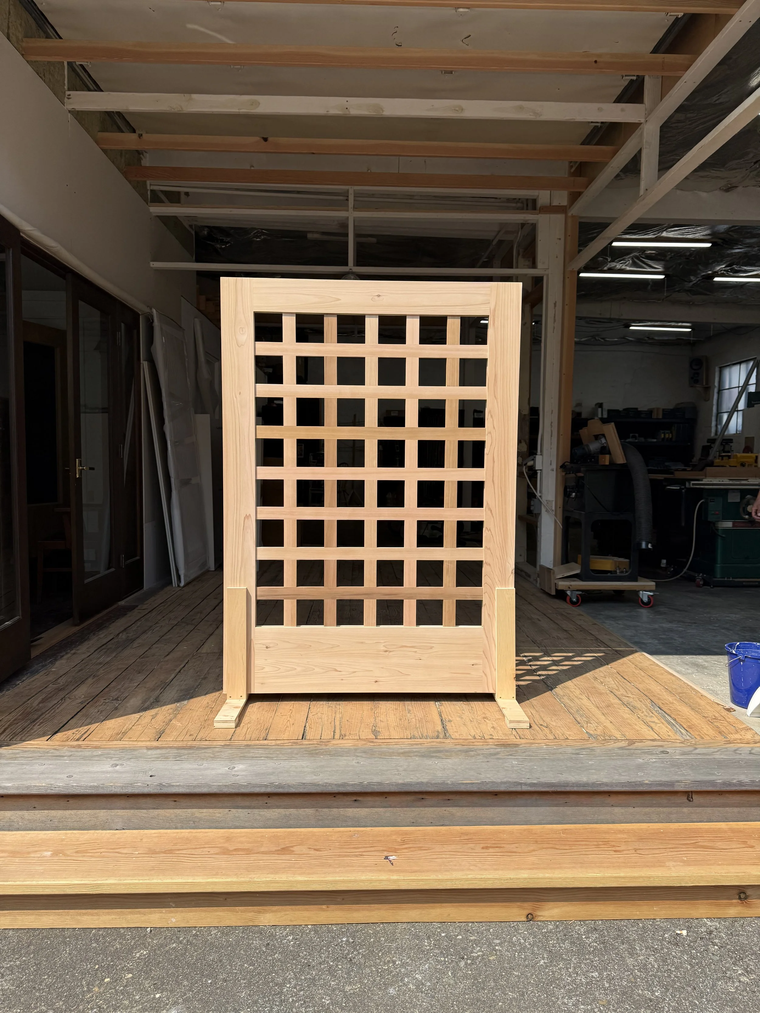 A cedar gate for a fence that is being displayed in the wood shop