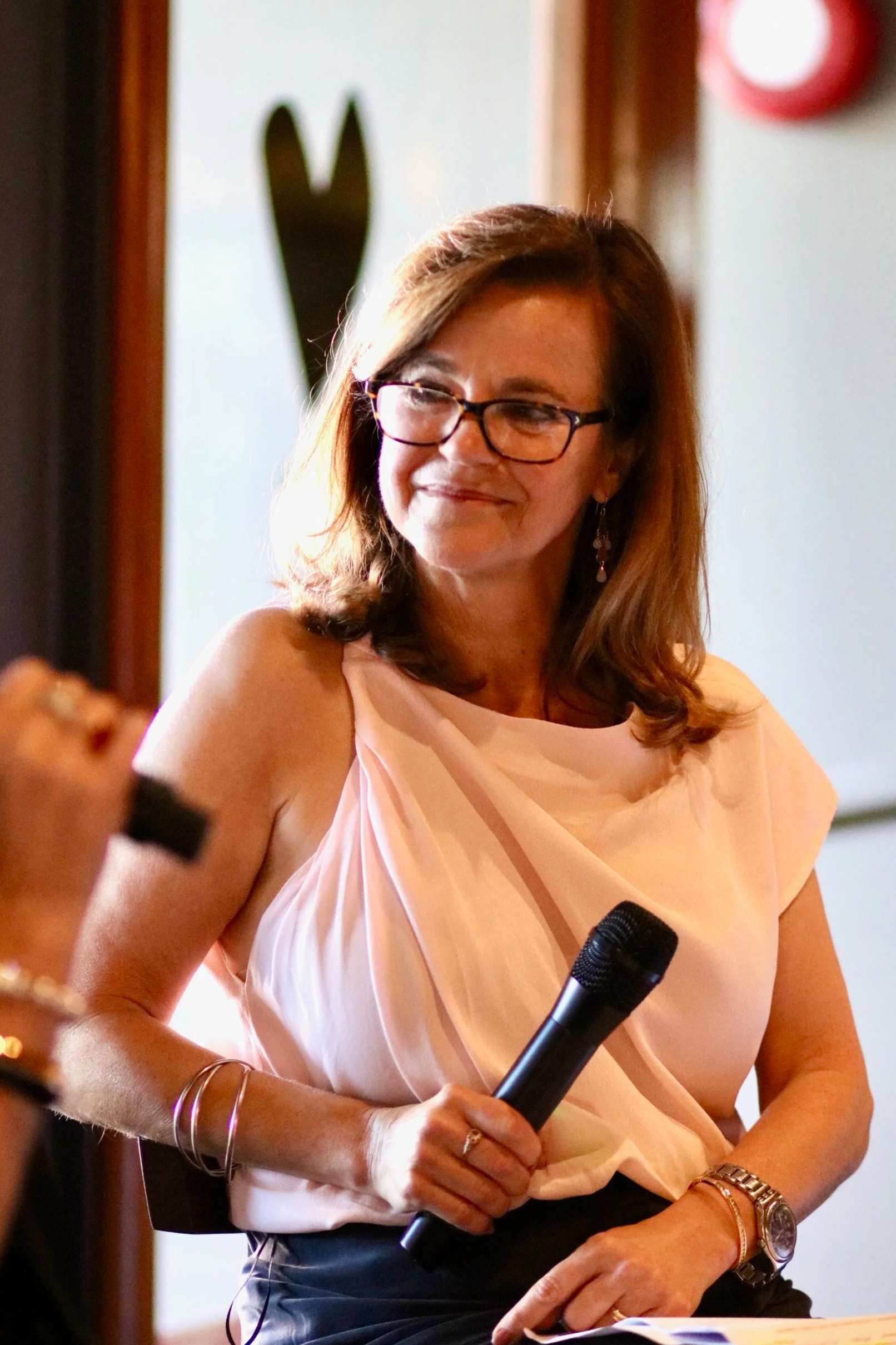 Nicole Abadee on stage with microphone