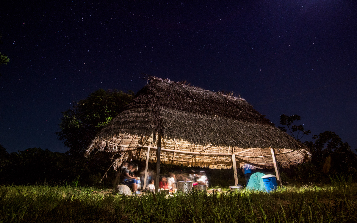 Members of the Matsigenka community Tayakome socialize into the late hours of the night drinking Masato; a nutritious and intoxicating beverage traditionally authorized to drink by the president of the community twice a year, on special ceremonies. As sedentary lives and modern amenities, such as these solar panels, replace customs, Masato is fast becoming a daily habit. April 22, 2016.